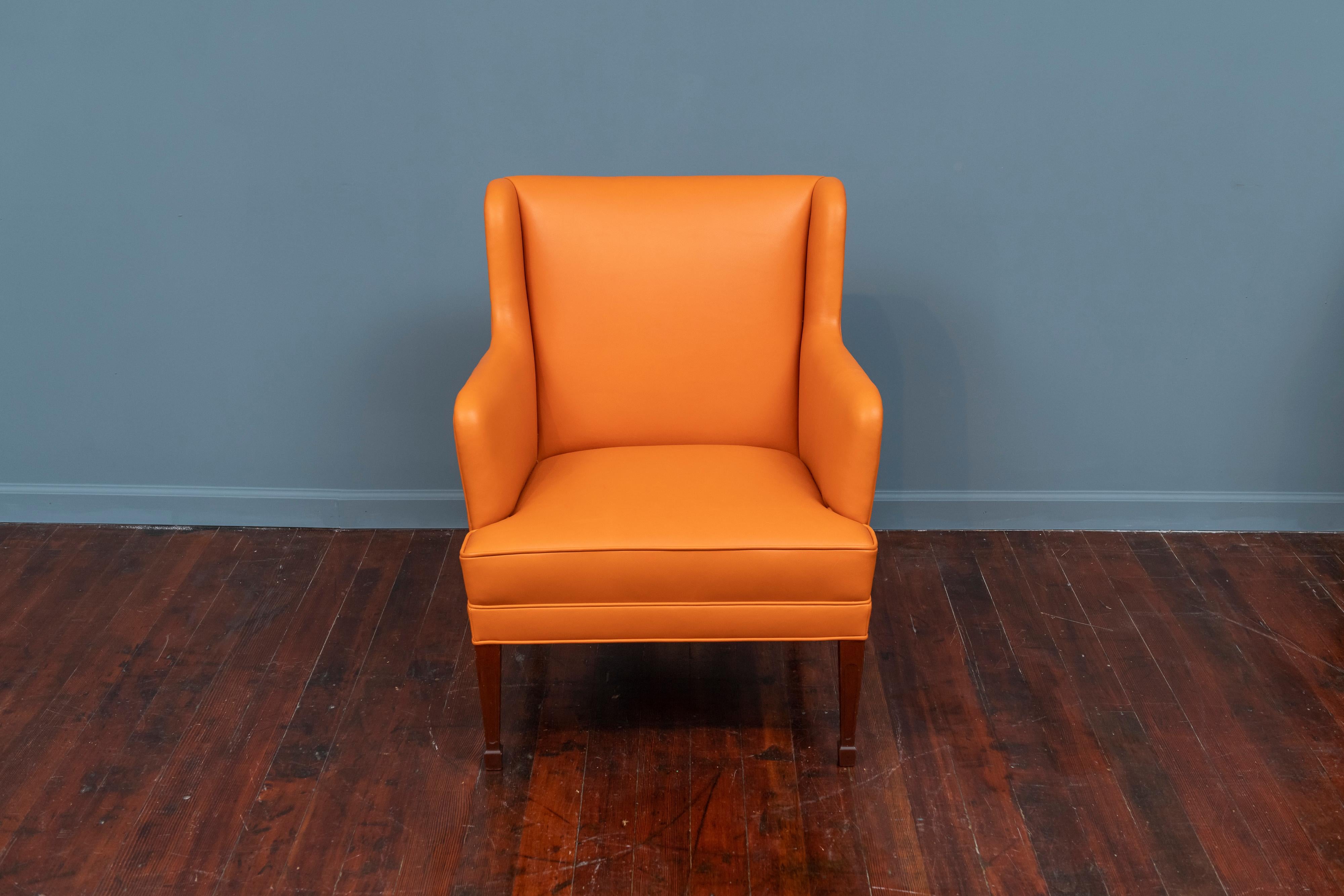 Frits Henningsen lounge chair with neoclassical style stained legs newly upholstered in luxurious feeling orange spinney beck leather with normal wear to all legs.