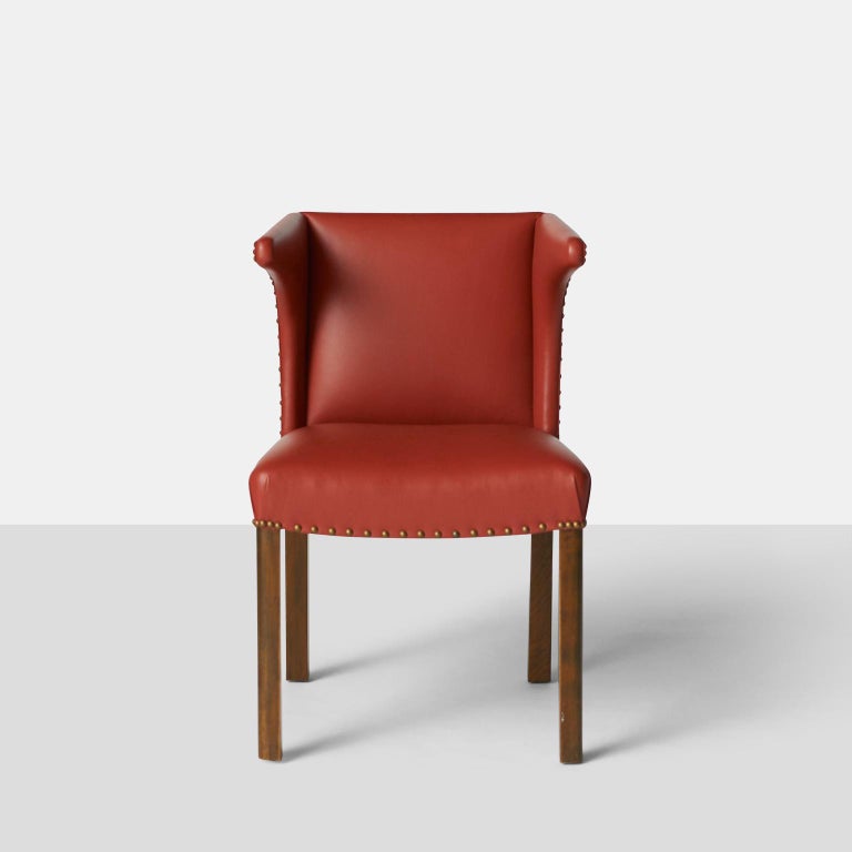 A rare easy chair of leather and mahogany with nail head trim. Designed by Frits Henningsen. Reupholstered in soft red leather and refinished mahogany with brass nail-heads.