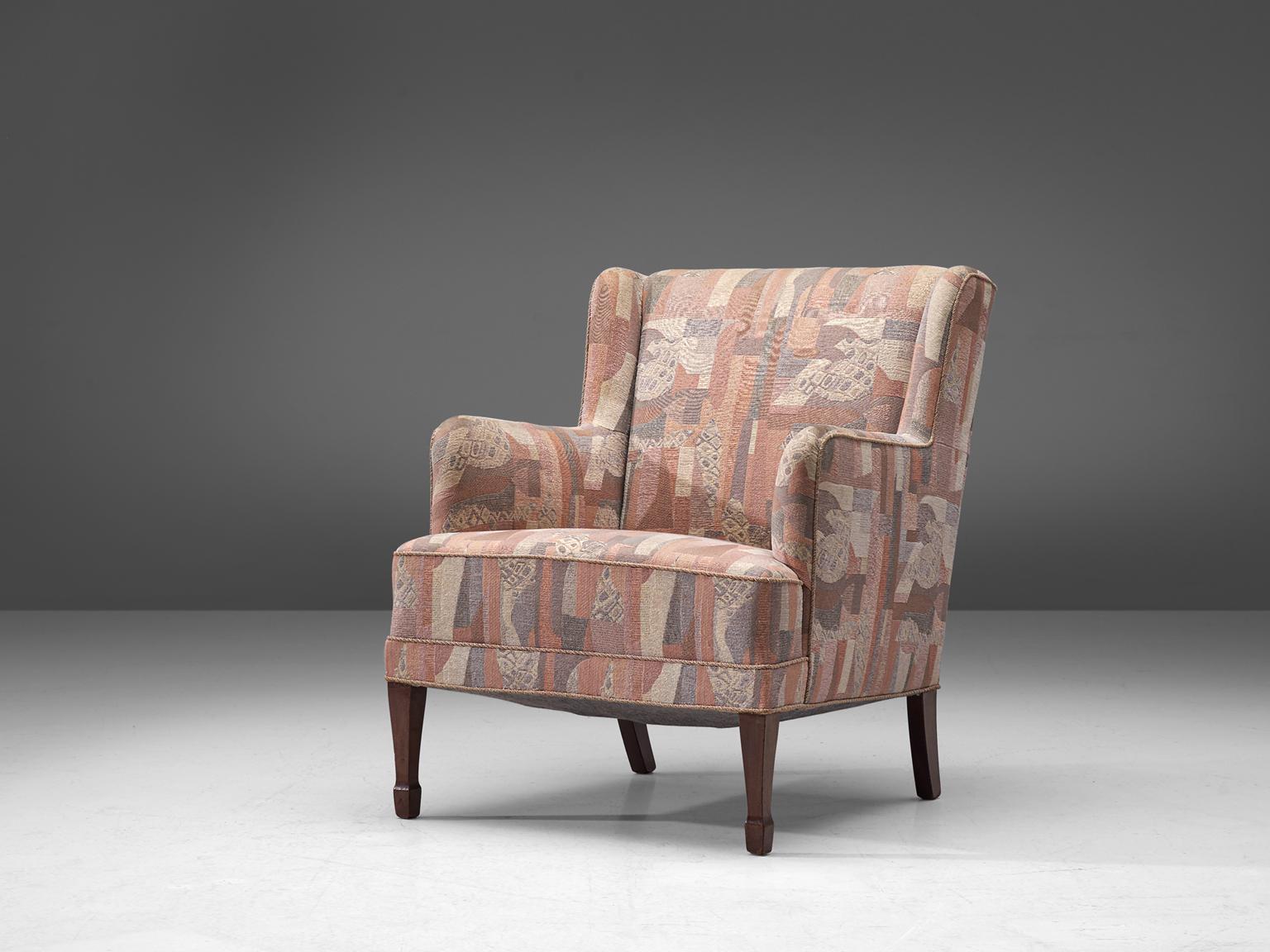 Frits Henningsen, wingback chair, multicolored pastel fabric, stained beech, Denmark 1930s

This modest yet refined armchair is a classic piece from designer Frits Henningsen. The four legs consist of stained beech. The backrests hold small wings,