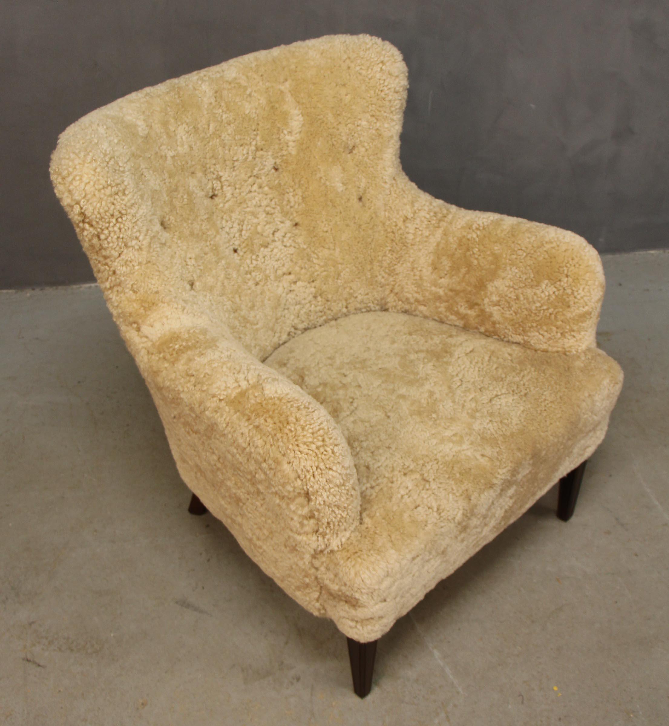 Frits Henningsen lounge chair new upholstered with shearling.

Legs of mahogany.

Made in the 1940s.

