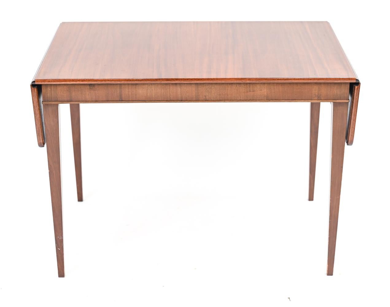An elegant Danish mid-century drop leaf side table in handsomely grained mahogany. Designed by Frits Henningsen, this table is characteristic of his transition from traditional furniture to Scandinavian modern minimalist design. Dimensions provided