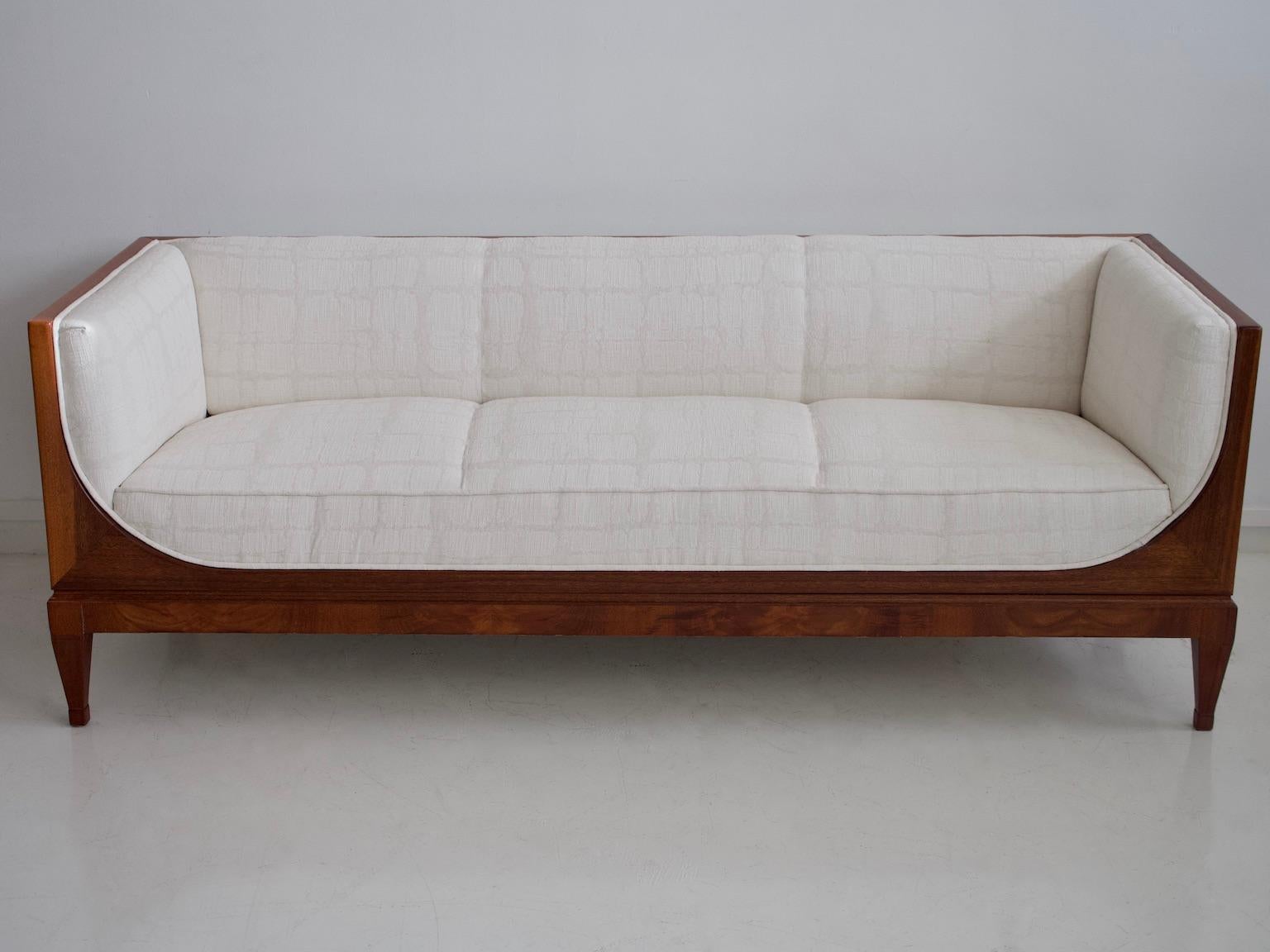 Beautiful box-shaped mahogany sofa designed by Frits Henningsen and produced in the 1940s. Front with rounded sleigh-shaped sides, tapered legs. Reupholstered in white textured fabric.