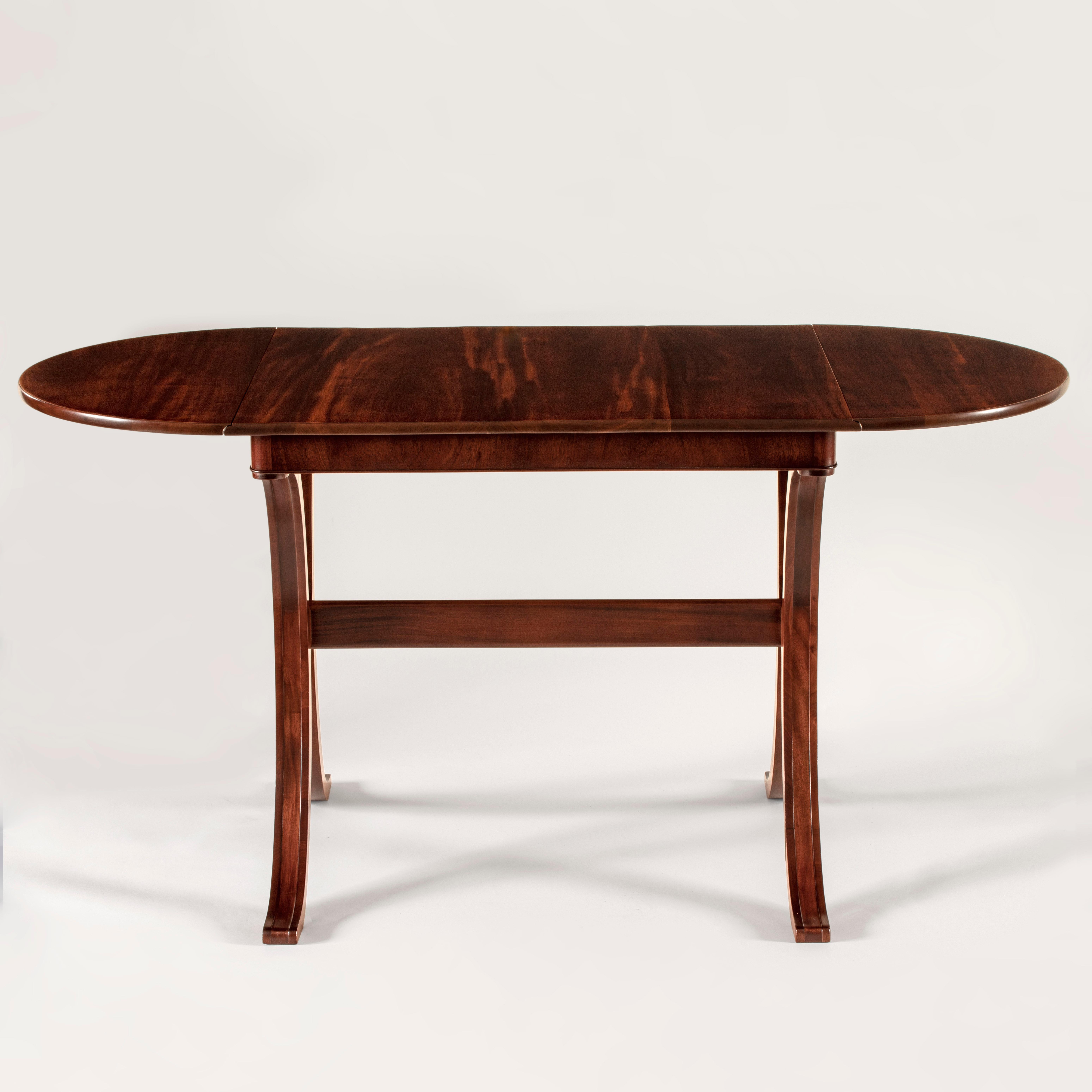 A rare solid wood example, superbly crafted inside and out by master cabinetmaker Frits Henningsen. The table has been expertly restored to best show-off the sumptuous and silky figured wood. 

The rectangular top with demilune drop-leaves,