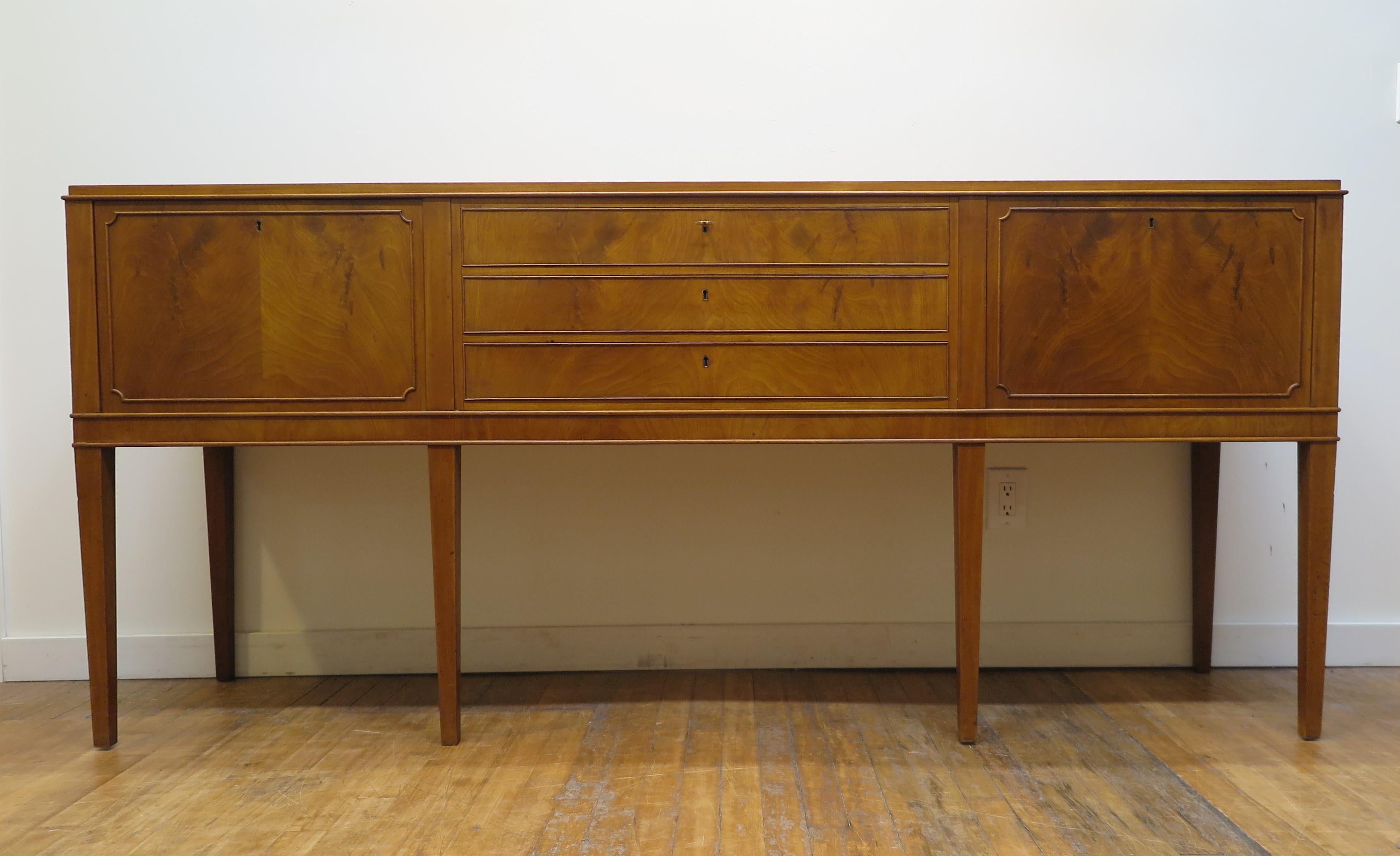 Frits Henningsen Mahogany Sideboard.  A Danish mahogany sideboard by cabinetmaker Frits Henningsen.  An executive styled sideboard having downward cabinet doors and three drawers all locking with two keys.  The Danish Design Movement of the 1920'