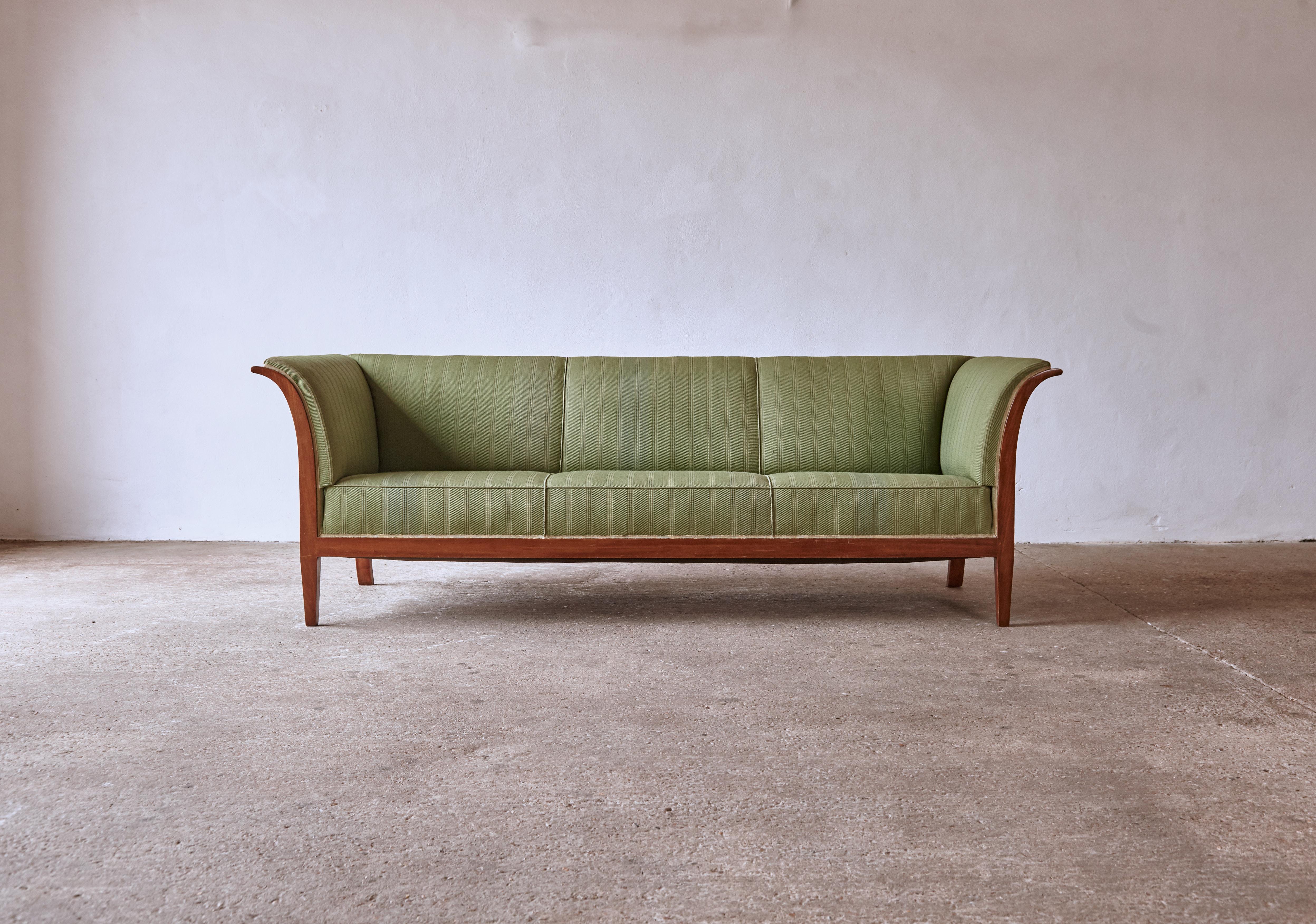 An original Frits Henningsen sofa, Denmark, 1940s-1950s. Designed and produced by Frits Henningsen, Copenhagen. The sofa has presumably been reupholstered at some point in its history but is easy to recover in different fabric if desired. The