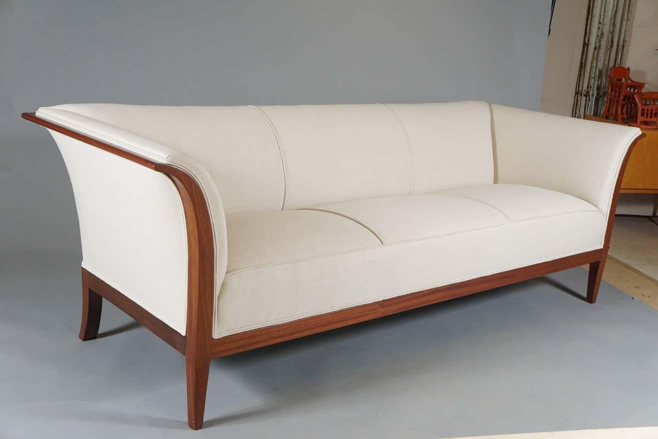 Elegant neo-classical-style sofa in mahogany by Danish designer Frits Henningsen 
Frits Henningsen (1889–1965) was a Danish furniture designer and cabinet maker who achieved high standards of quality with exclusively handmade pieces.

Henningsen