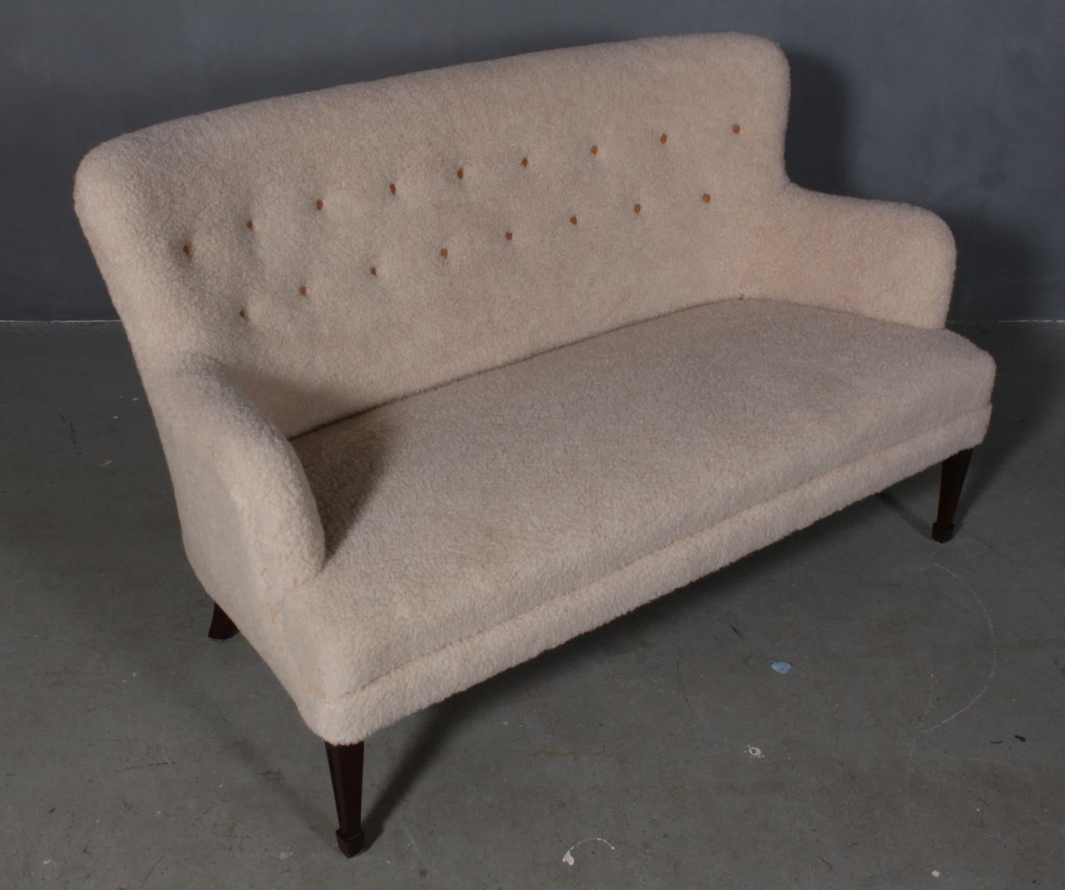 Frits Henningsen. Sofa new upholstered with lambswool, with leather buttons.

Legs of mahogany.

Designed in the 1930s, made by Frits Henningsen.
 