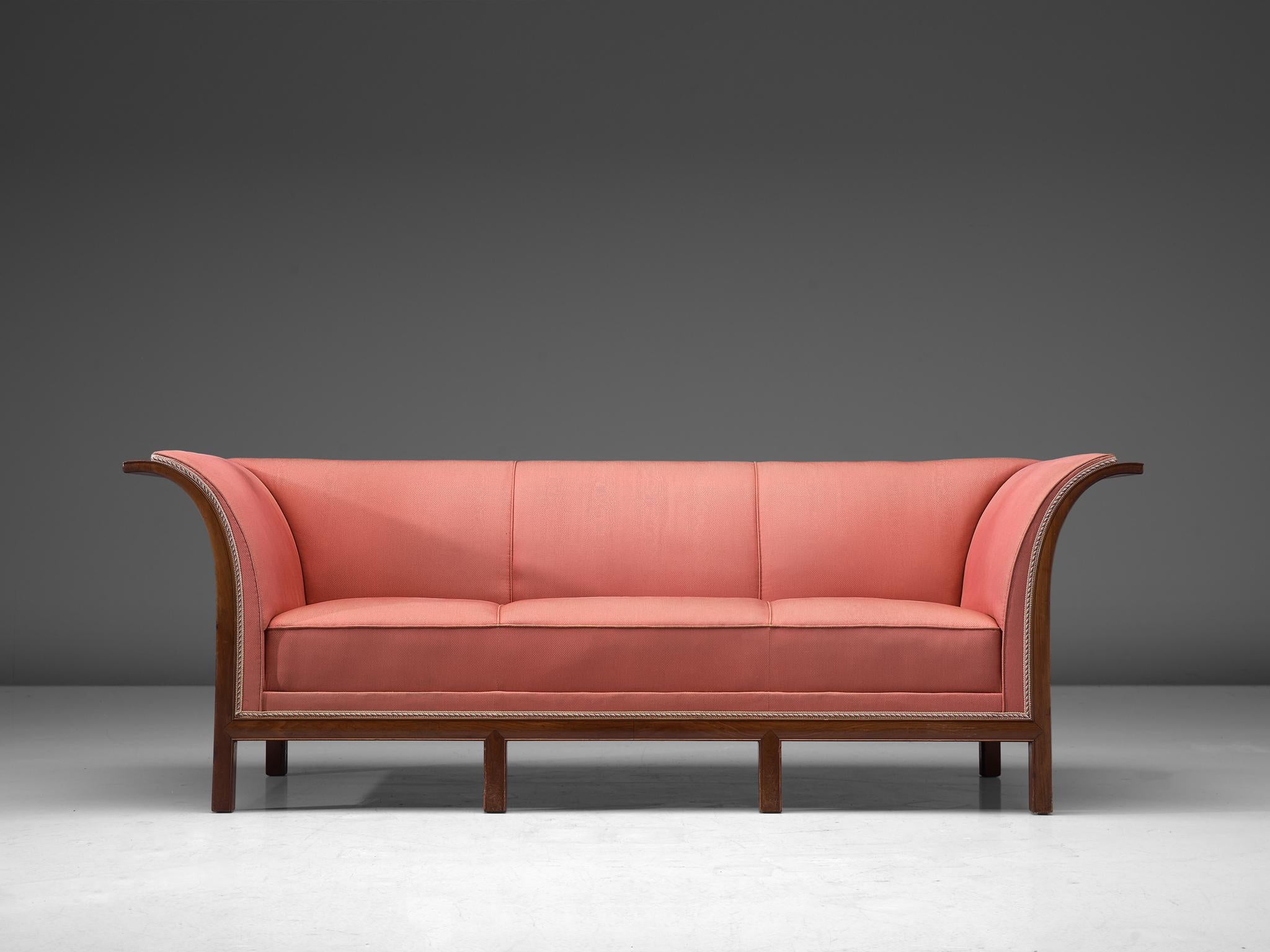Frits Henningsen, sofa in mahogany and pink fabric, Denmark, 1930s.

This classic sofa was designed and produced by master cabinet maker Frits Henningsen around the 1930s. The basic design is well balanced, showing an interesting contrast between