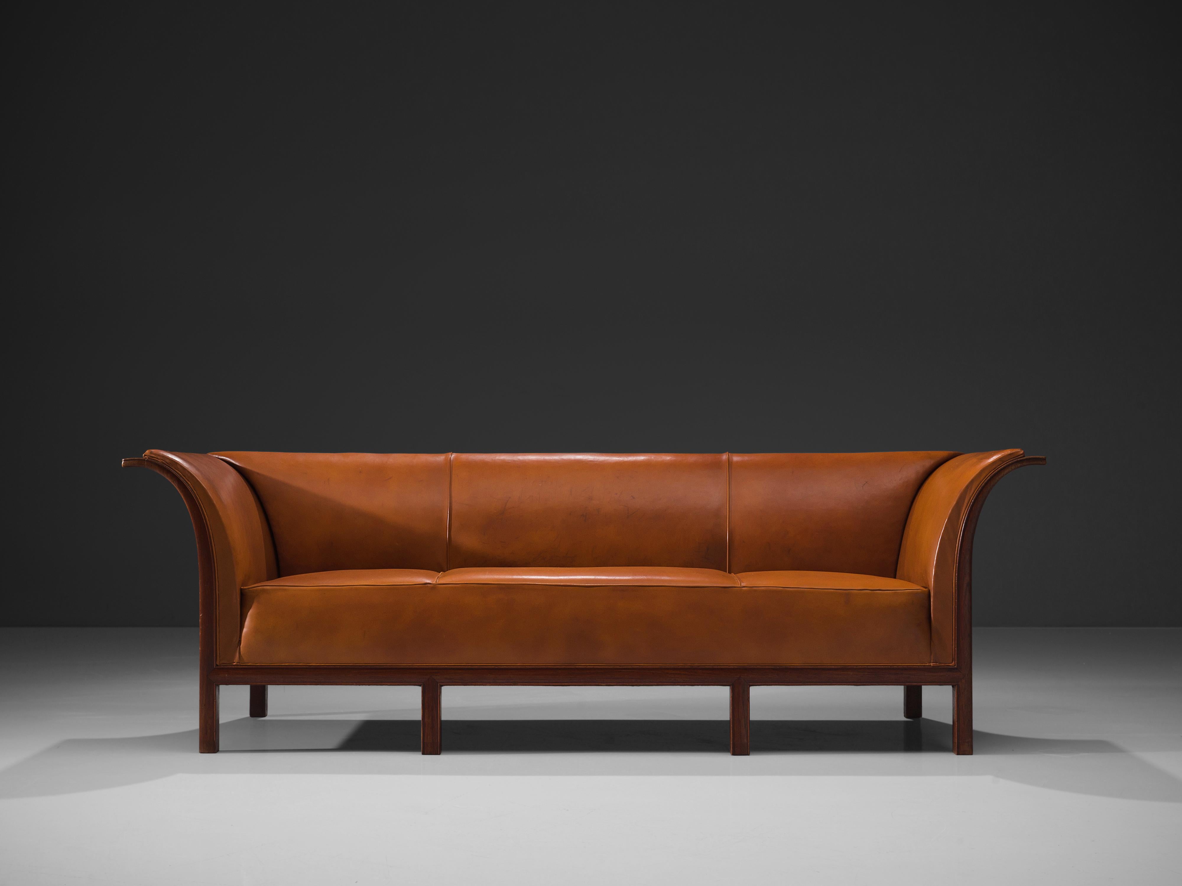 Frits Henningsen, sofa in teak, cognac leather, Denmark, 1930s

This classic sofa was designed and produced by master cabinetmaker Frits Henningsen in the 1930s. The design is well-balanced, showing an interesting contrast between the straight lines