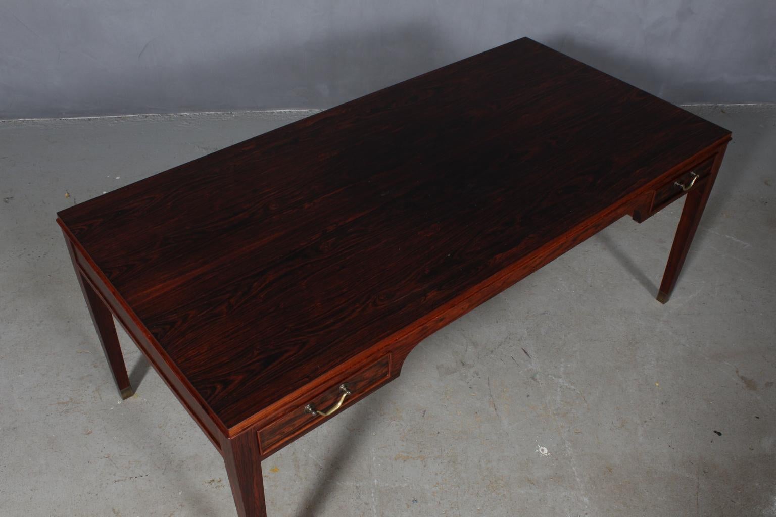 Frits Henningsen sofa table in rosewood and brass details. Four drawers.

Designed in the 1930s, made by Frits Henningsen.
 