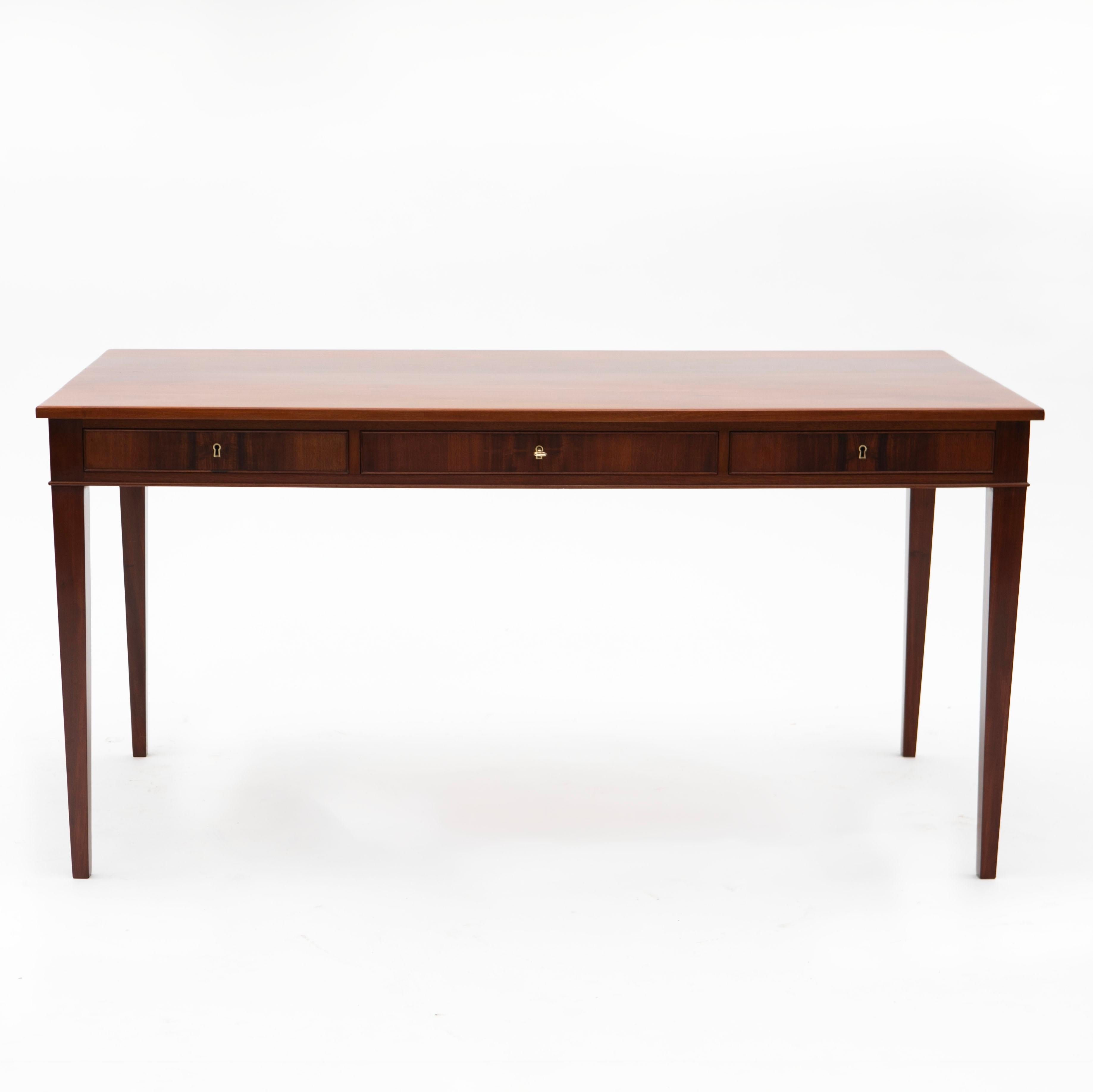 Frits Henningsen, Danish furniture designer and cabinet maker (1889-1965).
Solid Cuba mahogany writing table and chair.  The writing desk displays a rectangular top with molded edge above three cock beaded drawers with a molded edge. Raised on