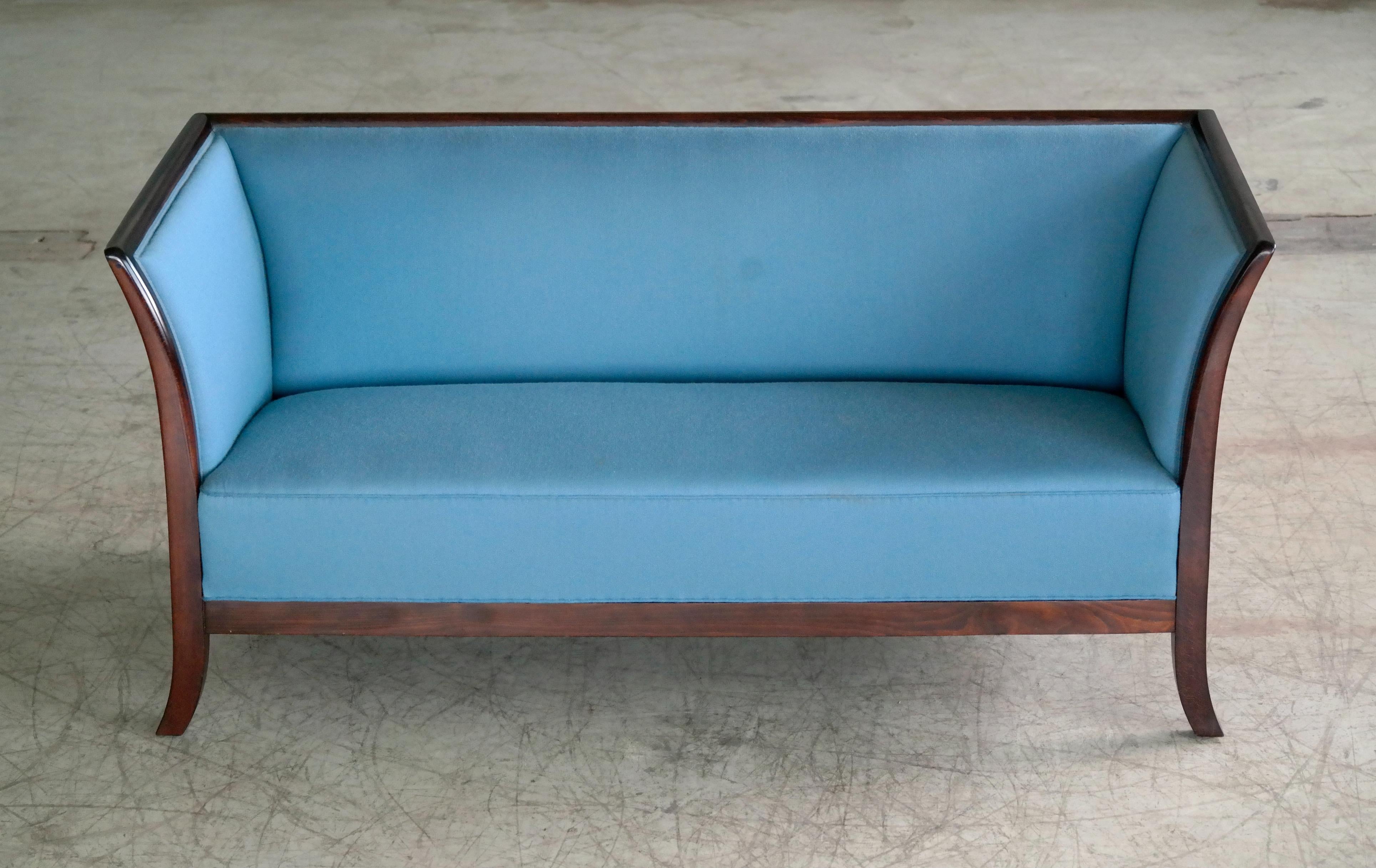 Beautiful and very elegant Frits Henningsen style sofa manufactured and marked with label by Søren Willadsen, one of Denmark's premiere furniture makers sometime in the early 1950s. Solid mahogany frame extending into flared legs. Later