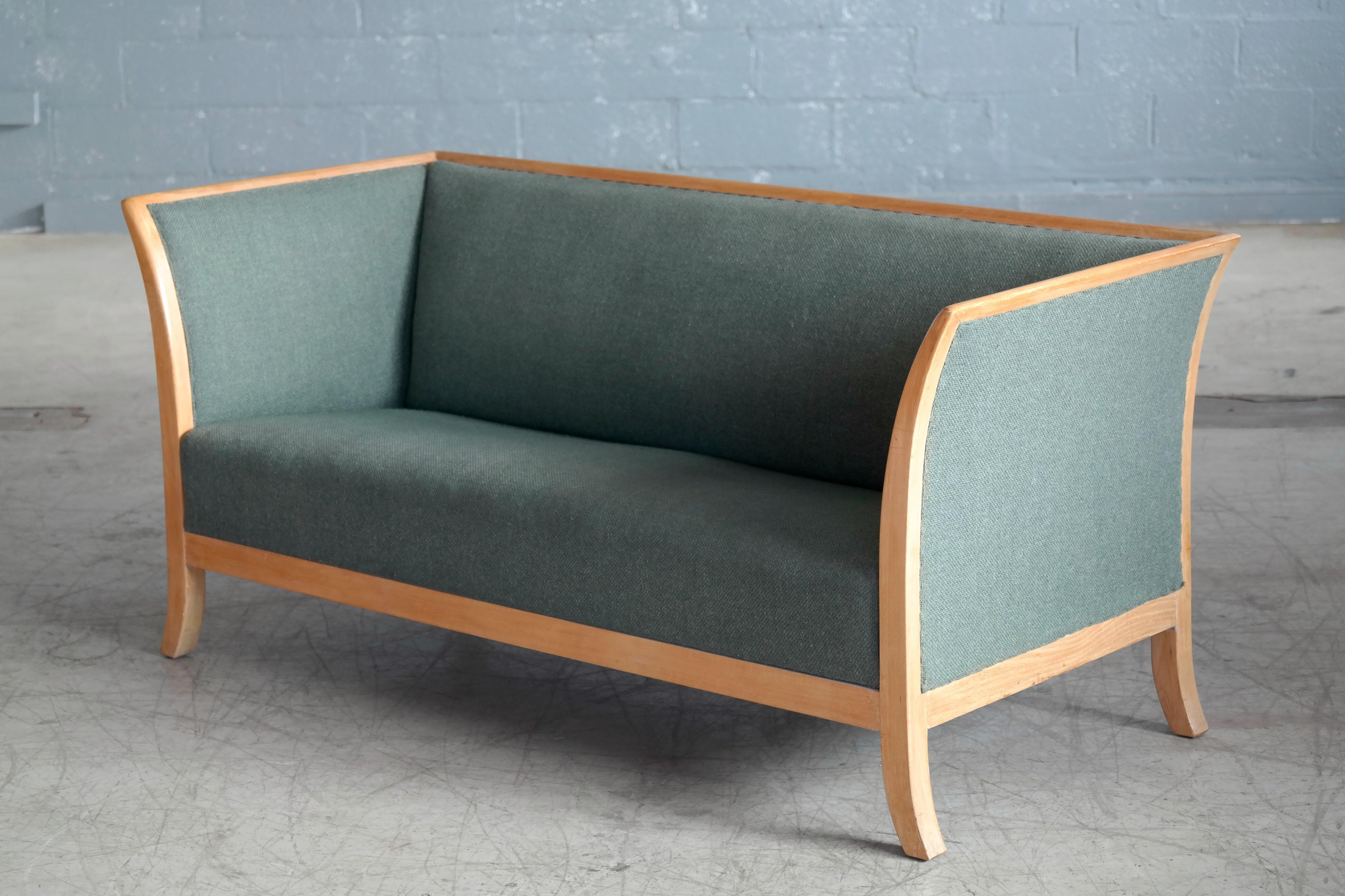Beautiful and very elegant Frits Henningsen style sofa manufactured and marked with label by Søren Willadsen, Denmark probably sometime in the 1930s-1940s. Framed in oak with the frame extending into flared legs. Later upholstered in sides, seat and