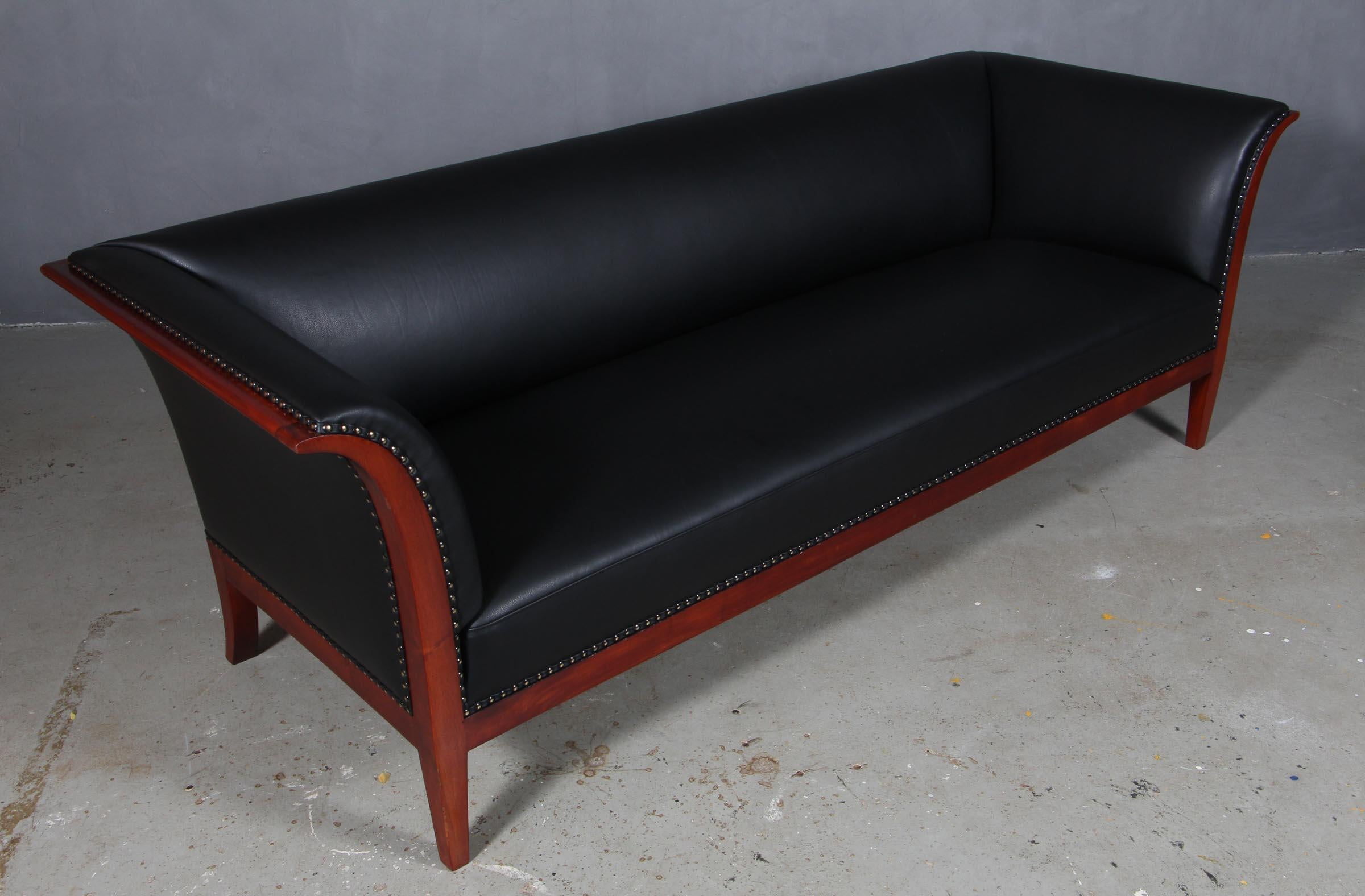 Frits Henningsen three seat sofa new upholstered with black aniline leather.

Frame of mahogany.

Made in the 1940s.

 