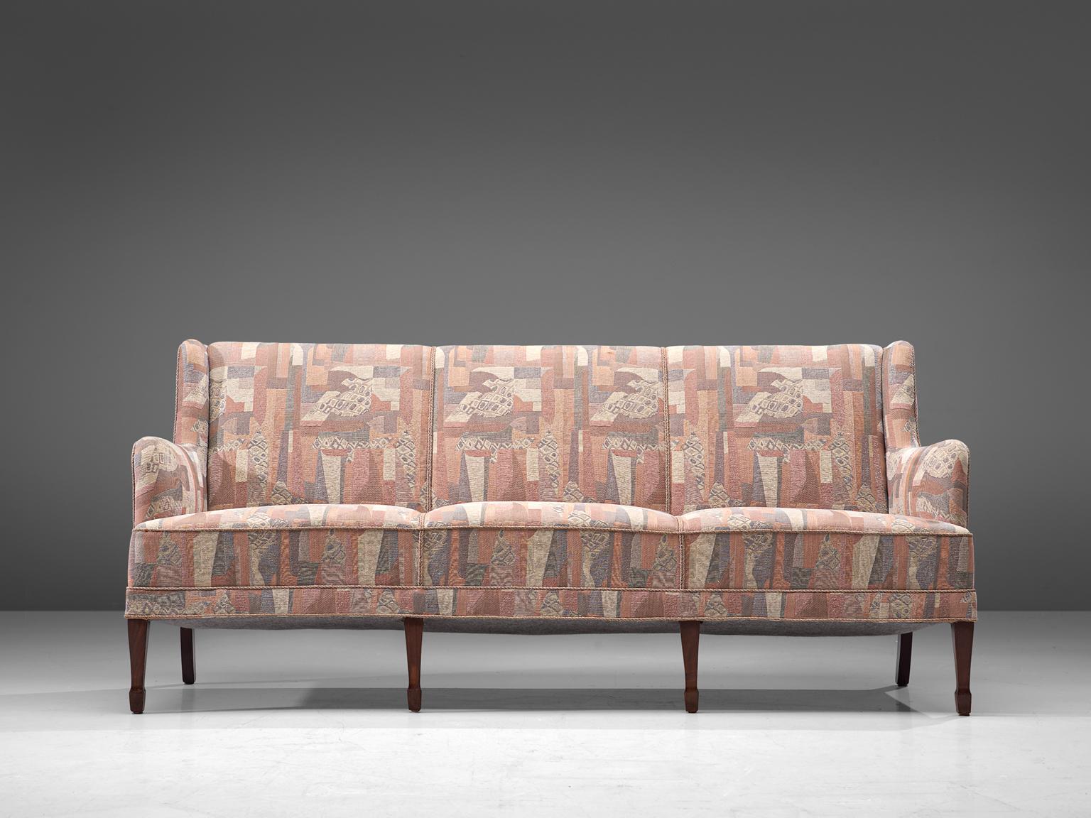 Frits Henningsen, three-seat sofa, fabric and oak, Denmark, 1940s. 

This elegant three-seat sofa is made by master cabinetmaker Frits Henningsen. This refined sofa is a classic pieces. The backrest holds small wings, which runs over into the