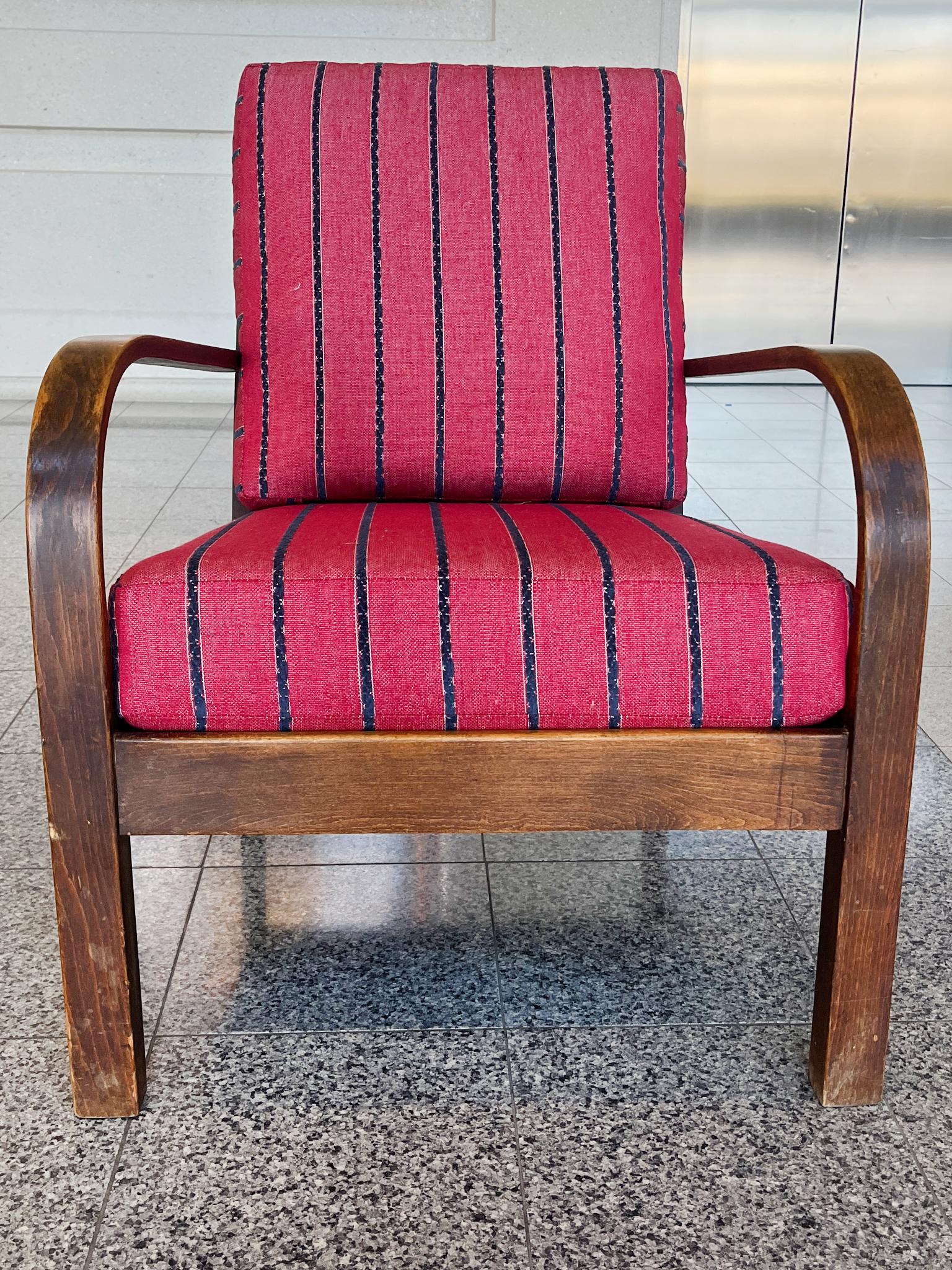 Handcrafted in the 1940s, this Danish Modern chair was designed by Frits Schlegel. It features a bentwood oak frame with a dark finish. The new upholstery is a striped linen weave with a bold palette of red and blue. Noteworthy design features