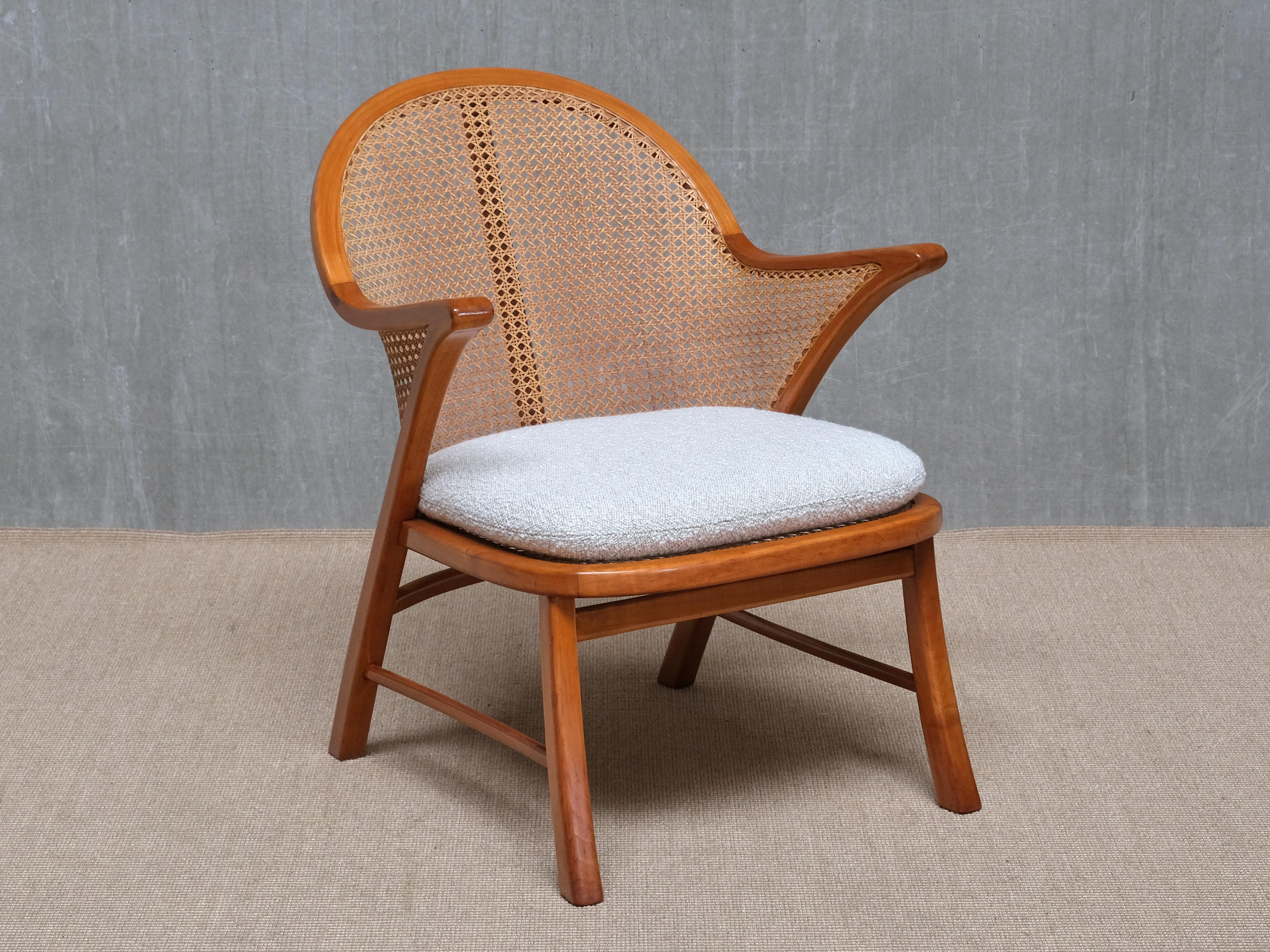 This rare armchair was produced in Denmark in the 1940s, and its striking design is attributed to Frits Schlegel.

The frame is crafted from solid cherrywood and retains its original Viennese cane seat and backrest. The flared rear legs sweep upward