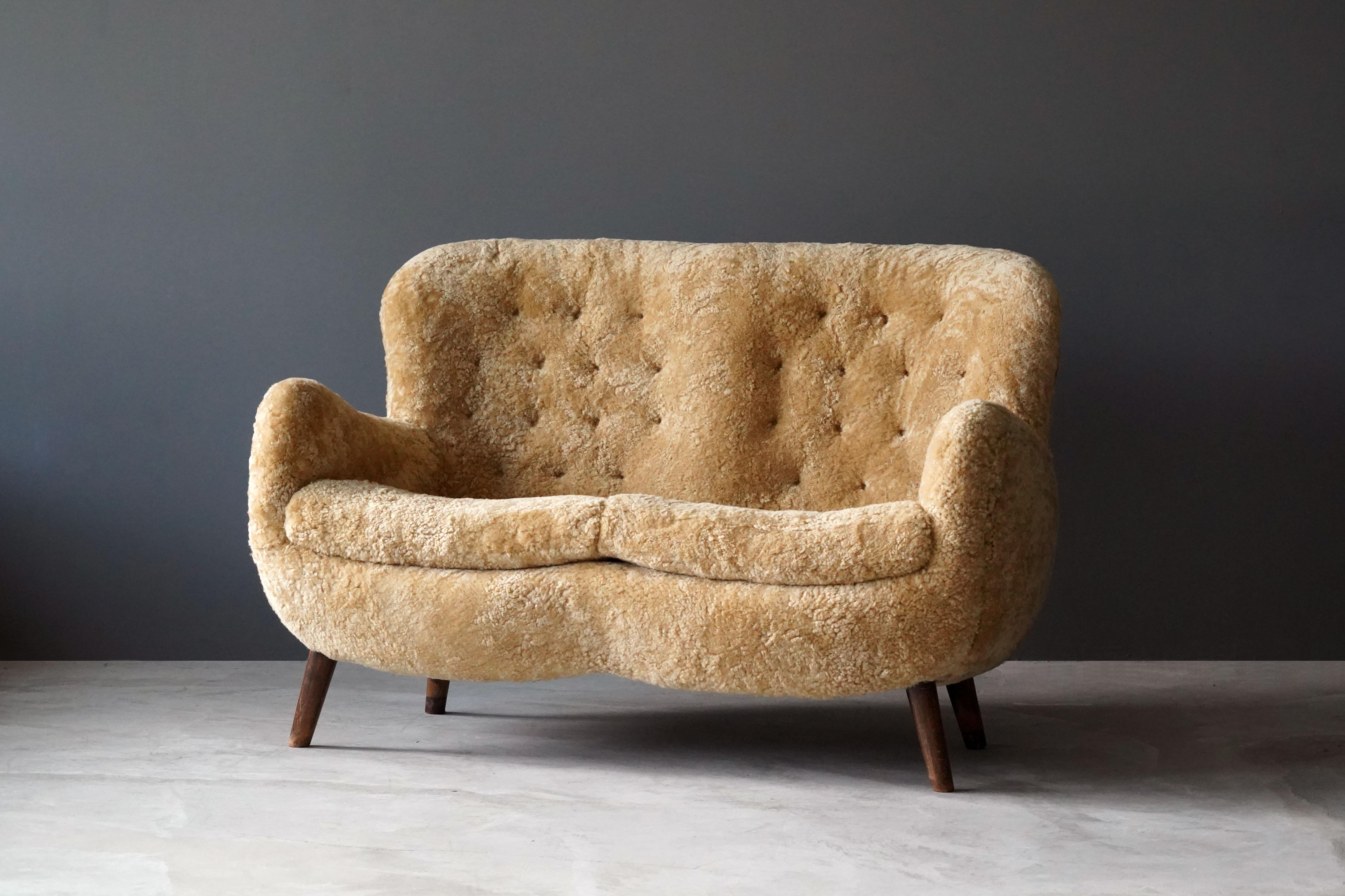 An example of early Danish modernism.

Upholstered in beige sheepskin contrasting dark wooden legs.

Frits Schlegel was a Danish modernist architect active during the same era as Flemming and Mogens Lassen, Philip Arctander, Viggo Boesen.
