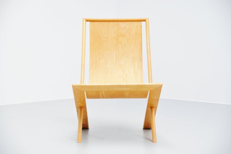 Very nice lounge chair designed and made by Frits Swart, Holland, 1979. Frits swart was a poet and craftsman. This chair has an amazing construction where a thin flexible plywood seat is fixed between the frame. The legs are supported by a metal