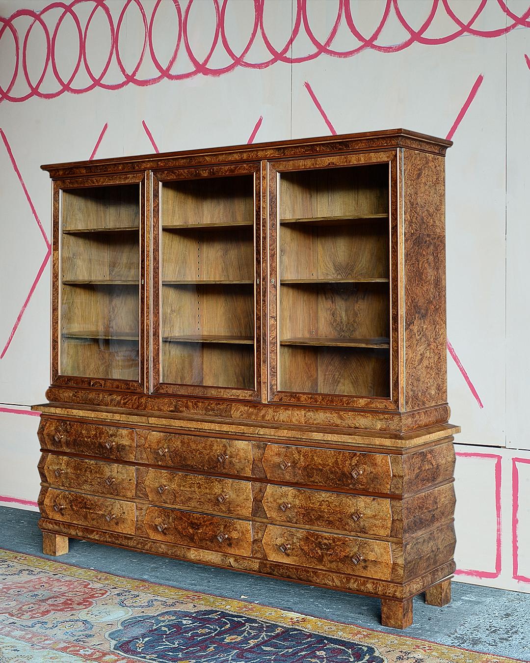 Este raro diseño de librería expresionista, creado por Fritz August Breuhaus, fue fabricado por H. Hömig, Hönningen, en Alemania Occidental.  Está chapado en nogal burilado e incluye nueve cajones. Este modelo se exhibió originalmente en la