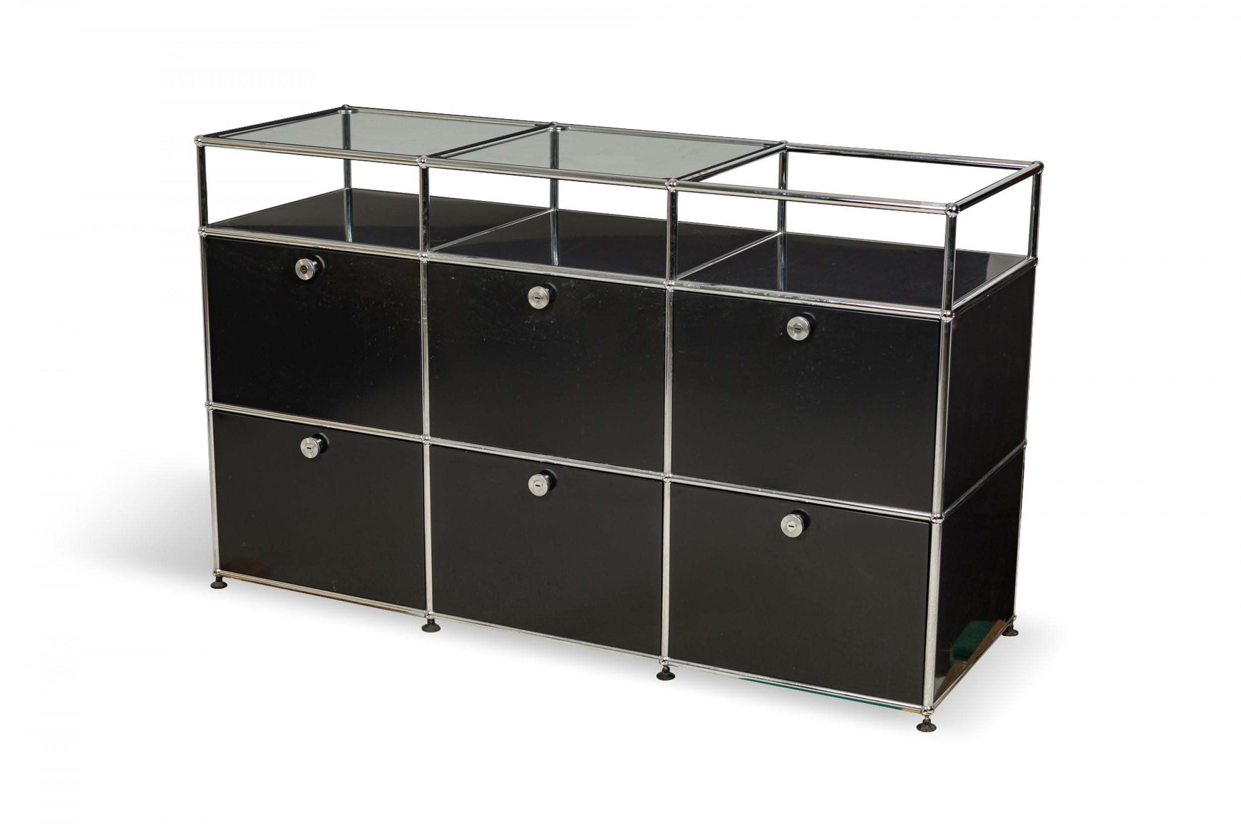 American Mid-Century display / storage cabinet with a lower black powder coated steel cabinet with six compartments below three open upper compartments, framed in a chrome plated steel tube structure under two clear glass panels. (FRITZ HALLER FOR
