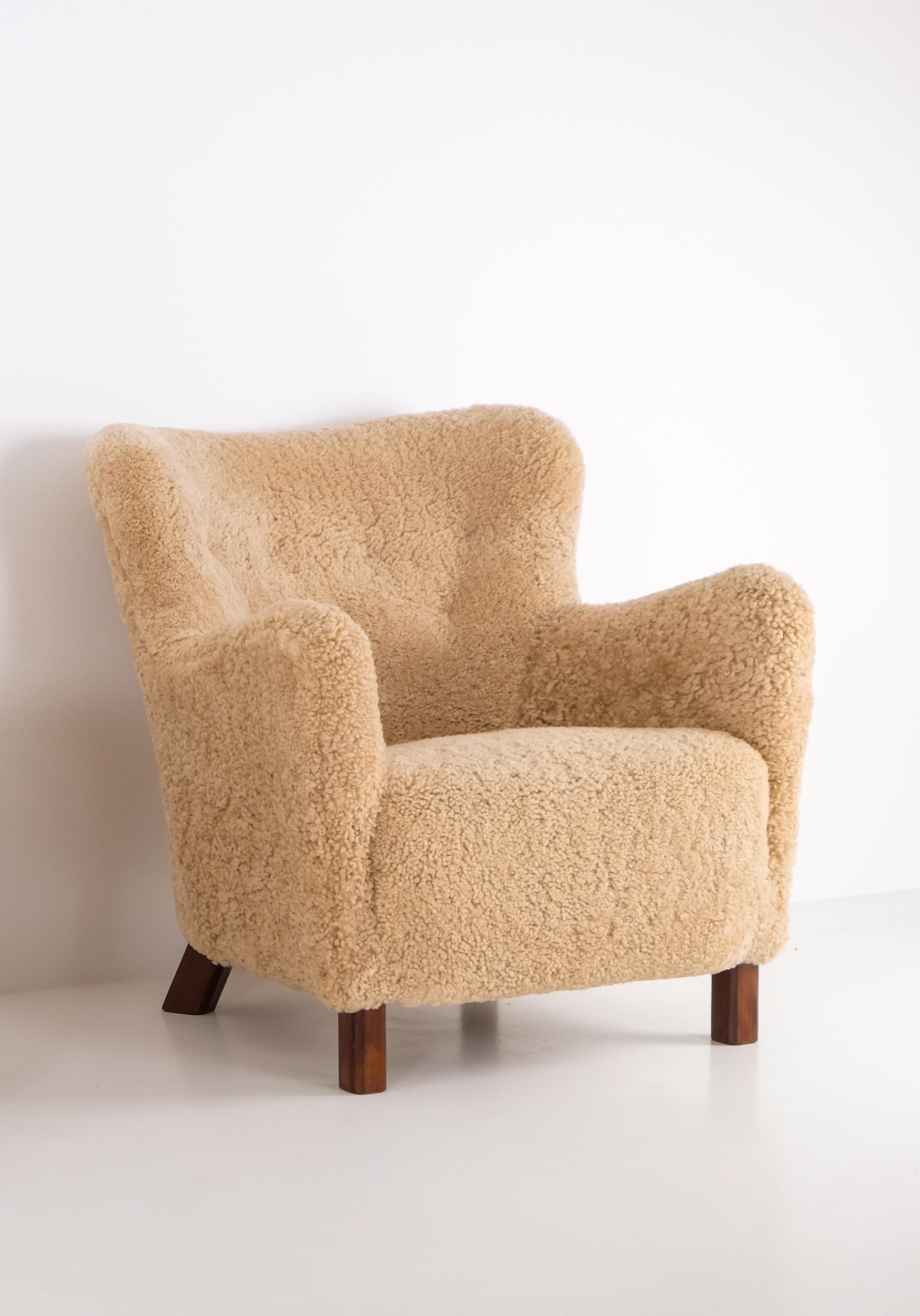 Newly upholstered in honey colored sheepskin. Produced by Fritz Hansen in Denmark, 1940s. 
Very good condition.