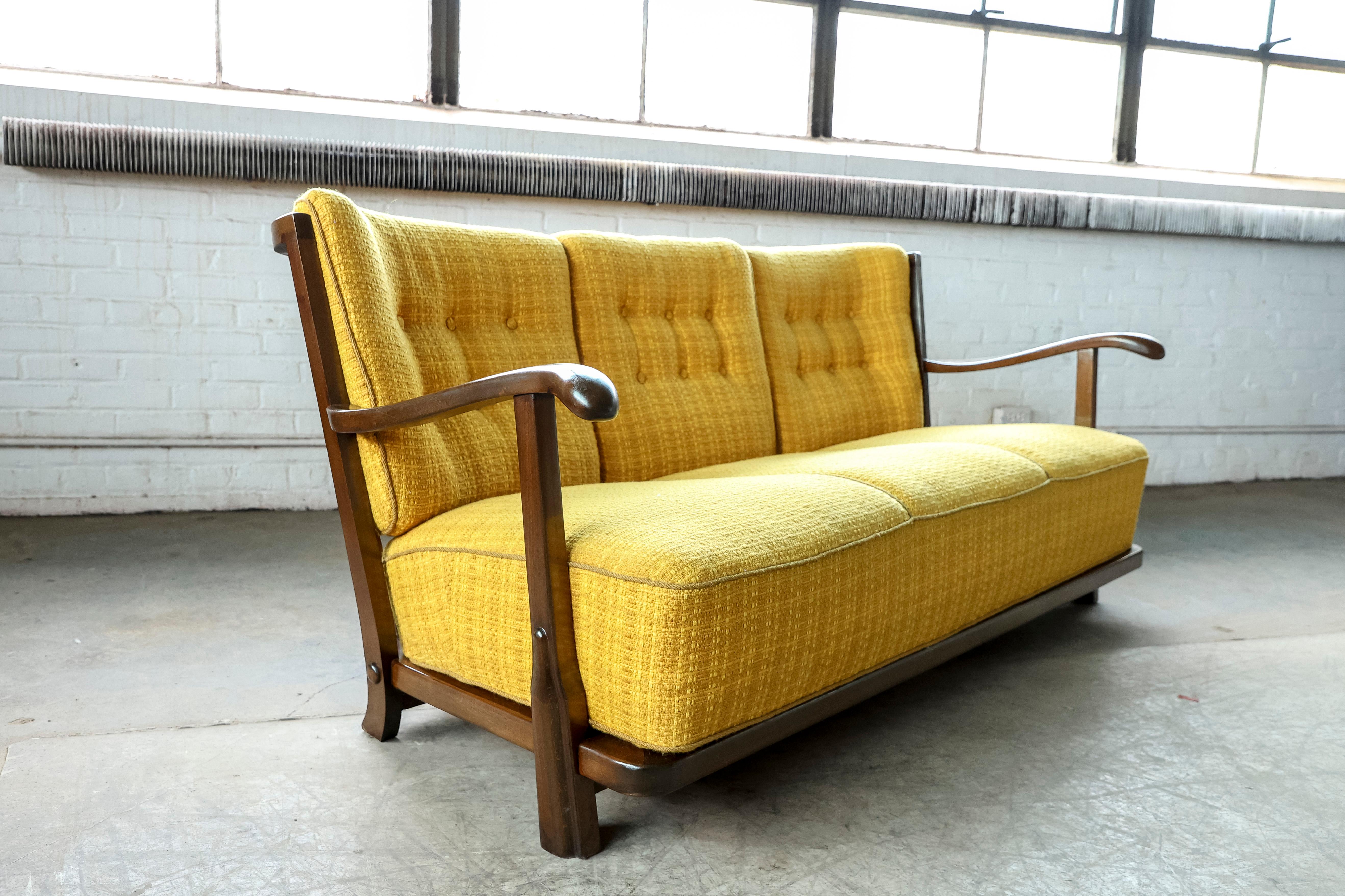 Rare and sought after sofa model 1594 made by Fritz Hansen, Denmark in the early 1940s. The sofa was featured in Fritz Hansen's production catalog in 1942 page 6. It's a magnificent piece with low slung lines all built on a frame of stained solid