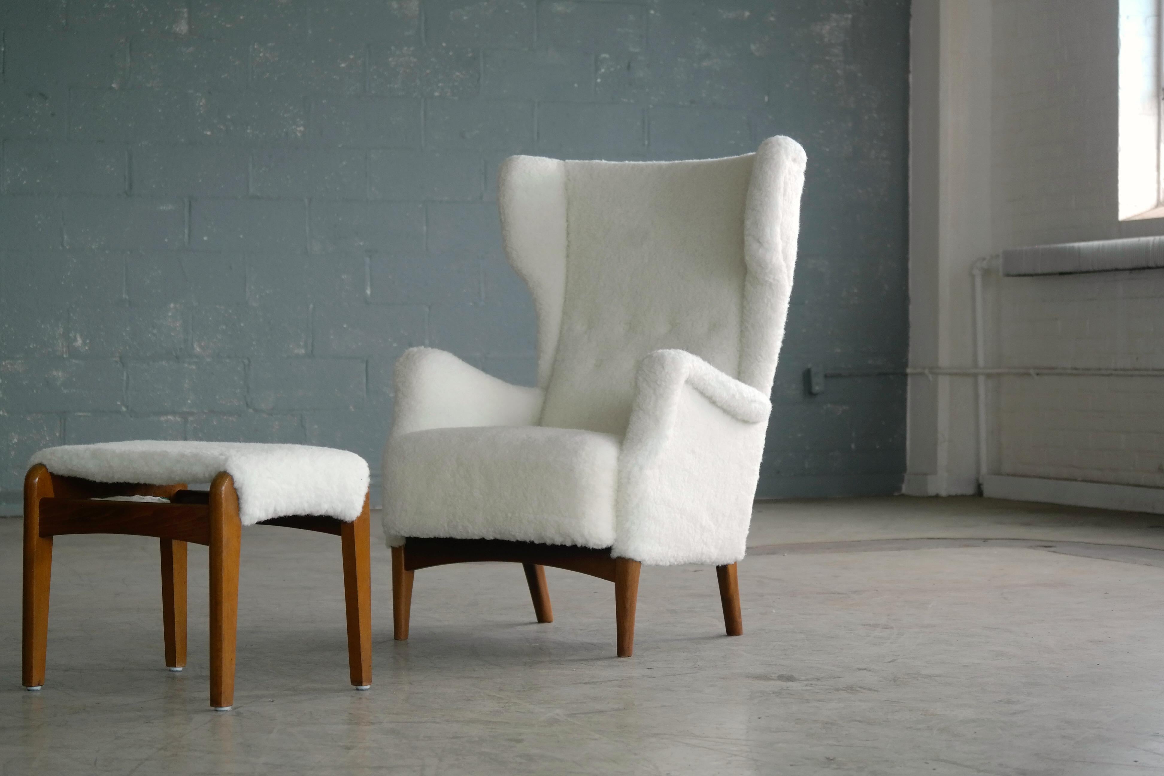Fantastic Danish midcentury wingback chair model 8023 designed and first seen in Fritz Hansen's 1951 catalog. The matching ottoman is a model 1164 by Fritz Hansen and both pieces were made at Fritz Hansen factory in Denmark in the early 1950s. Very