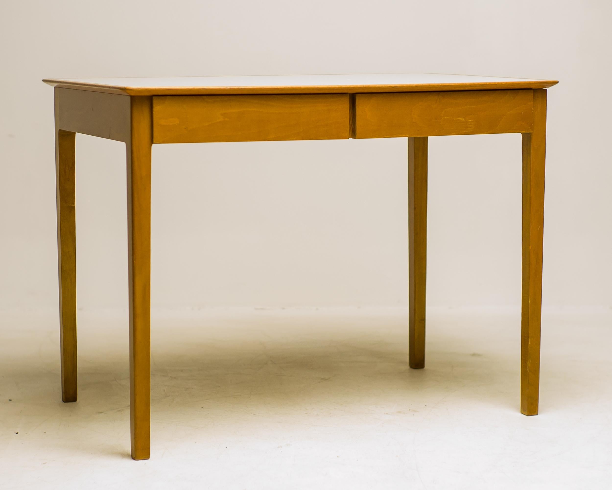 This compact desk by Fritz Hansen combines clean Scandinavian design with everyday practicality. Crafted in warm maple with a light laminate top, it offers a bright, durable surface that’s easy to maintain — perfect for daily use.

Its two drawers