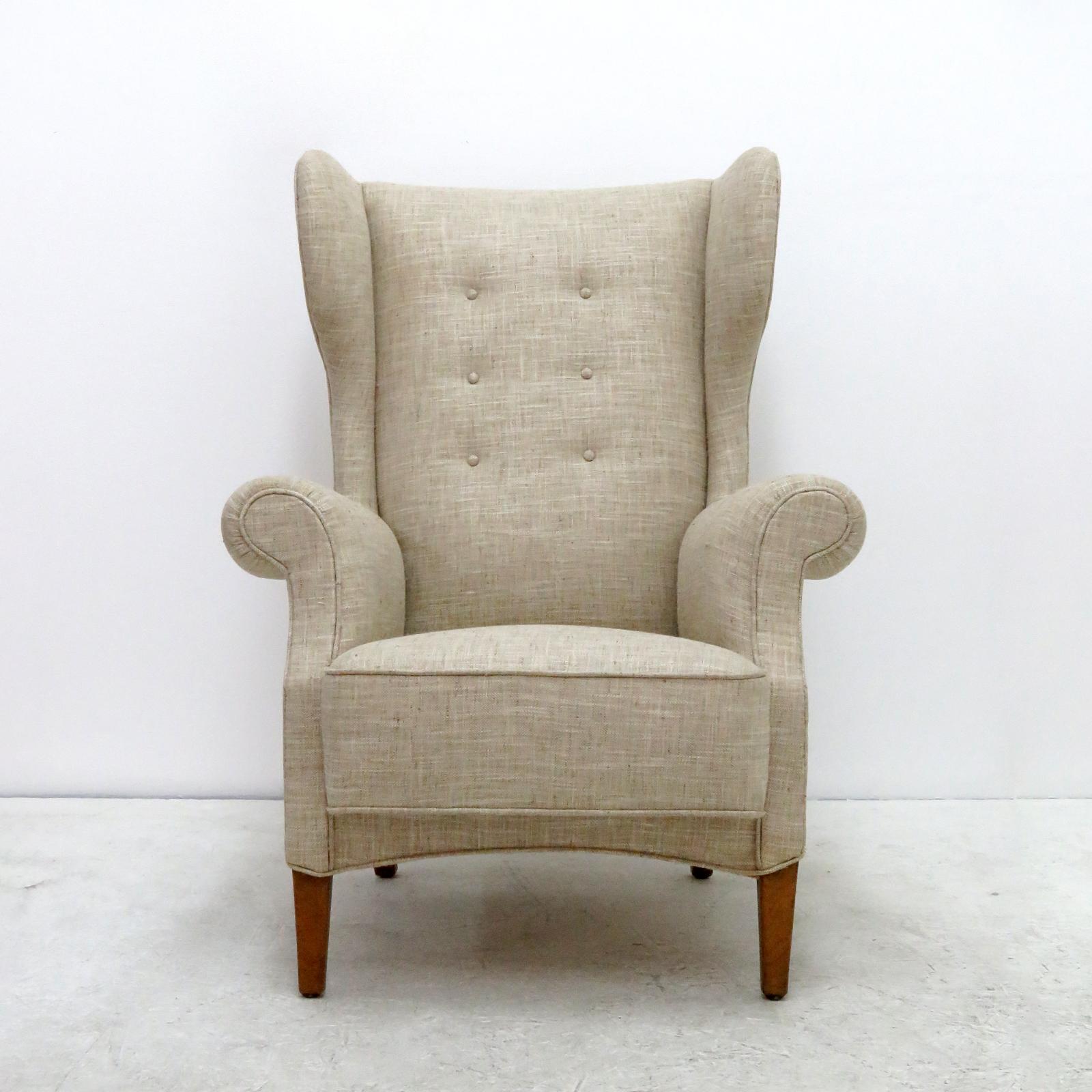 Wonderful Danish 8000 series high wingback armchair by Fritz Hansen, professionally reupholstered body on a solid wood frame with hand tied spring seat structure and button tufted back.