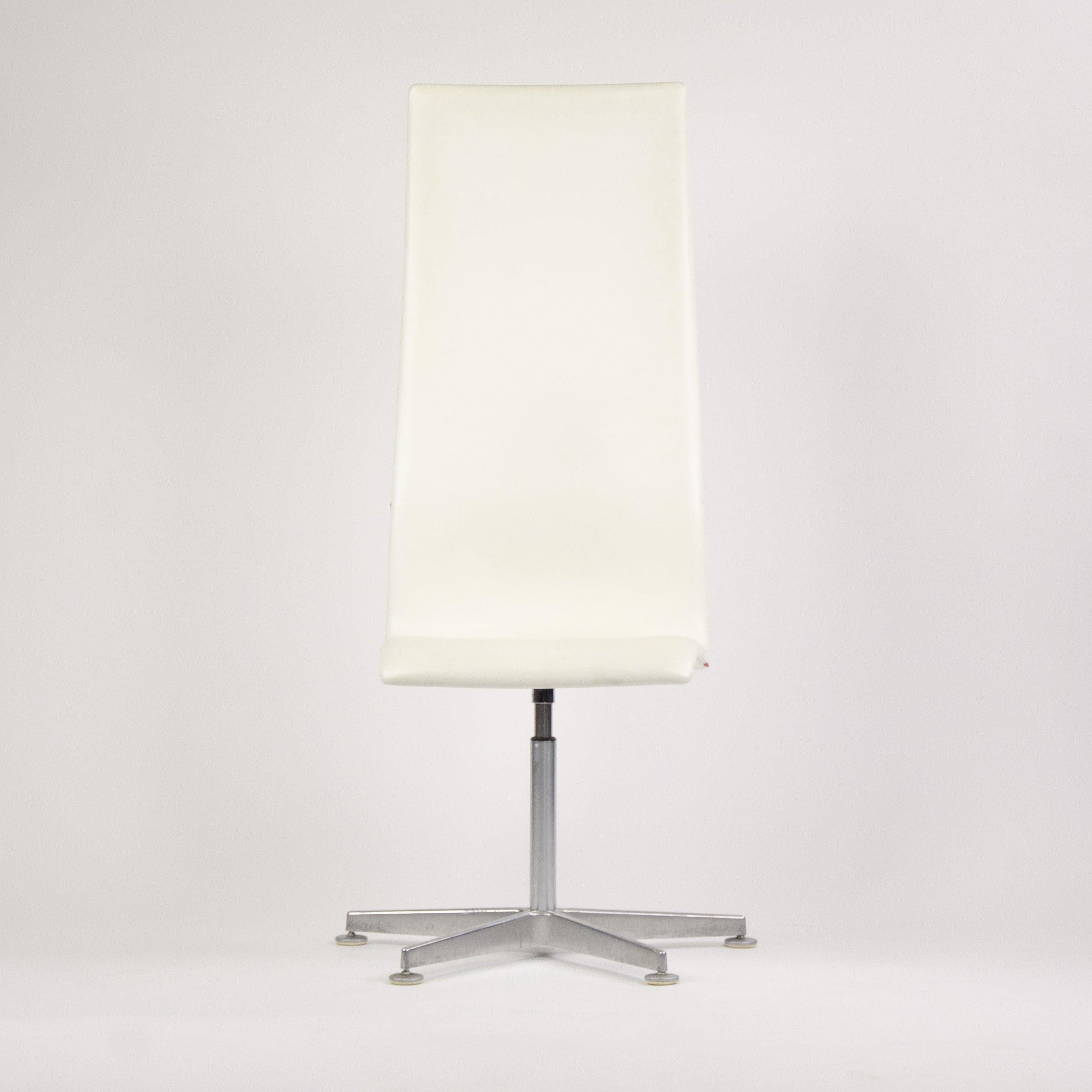 Listed for sale is an authentic (sold individually) labelled Arne Jacobsen tall oxford chair in white leather with a lovely brushed aluminum base.Four chairsare available.  

The chairs were manufactured in 2007 for a very high end high-rise in
