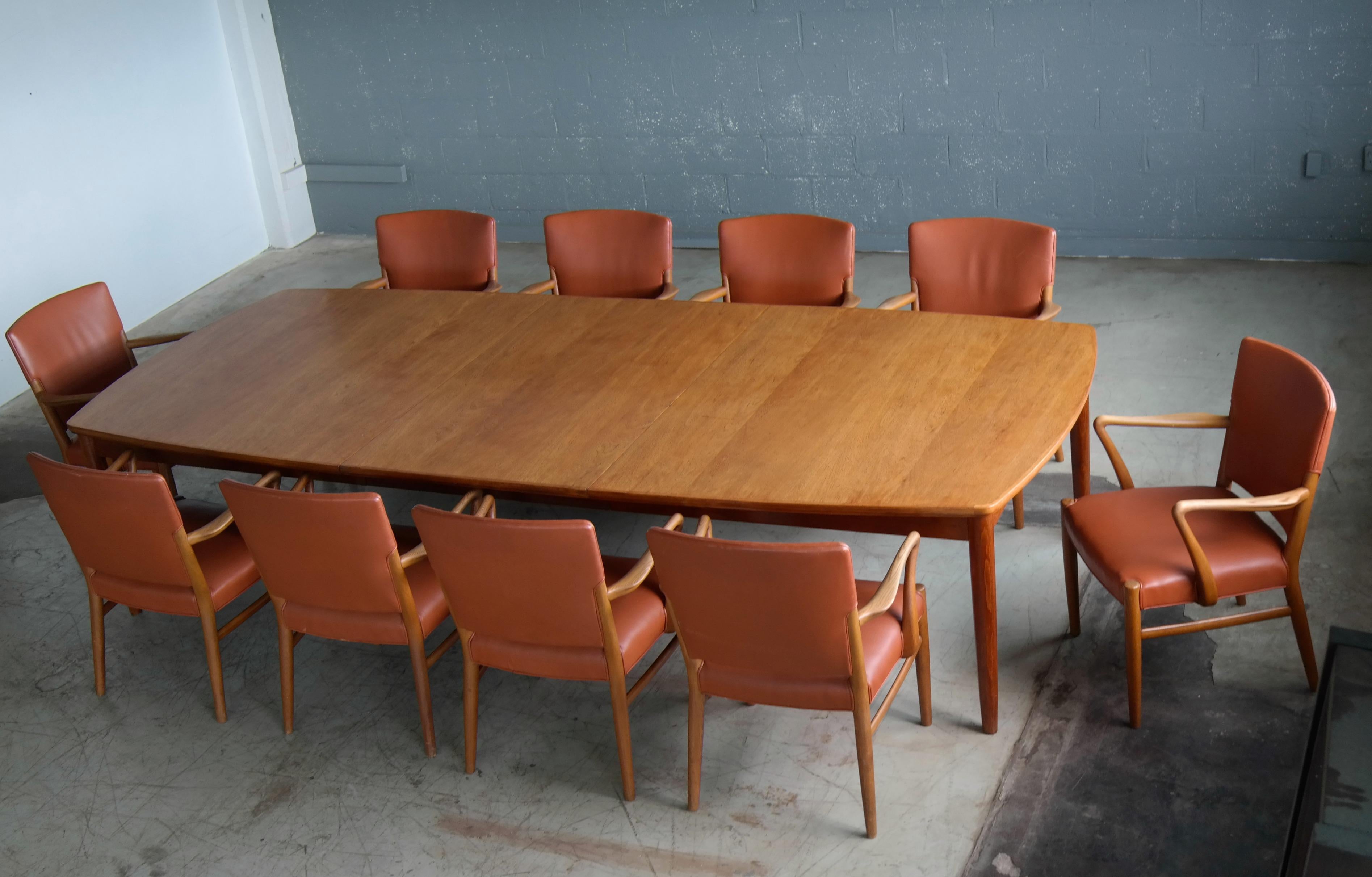 Rare to find fantastic set of 8 midcentury Danish conference chairs and table manufactured in the late 1960s. Beautiful armrests and legs in carved elmwood with great grain and color. The chairs are very much in the style of Fritz Hansen but the