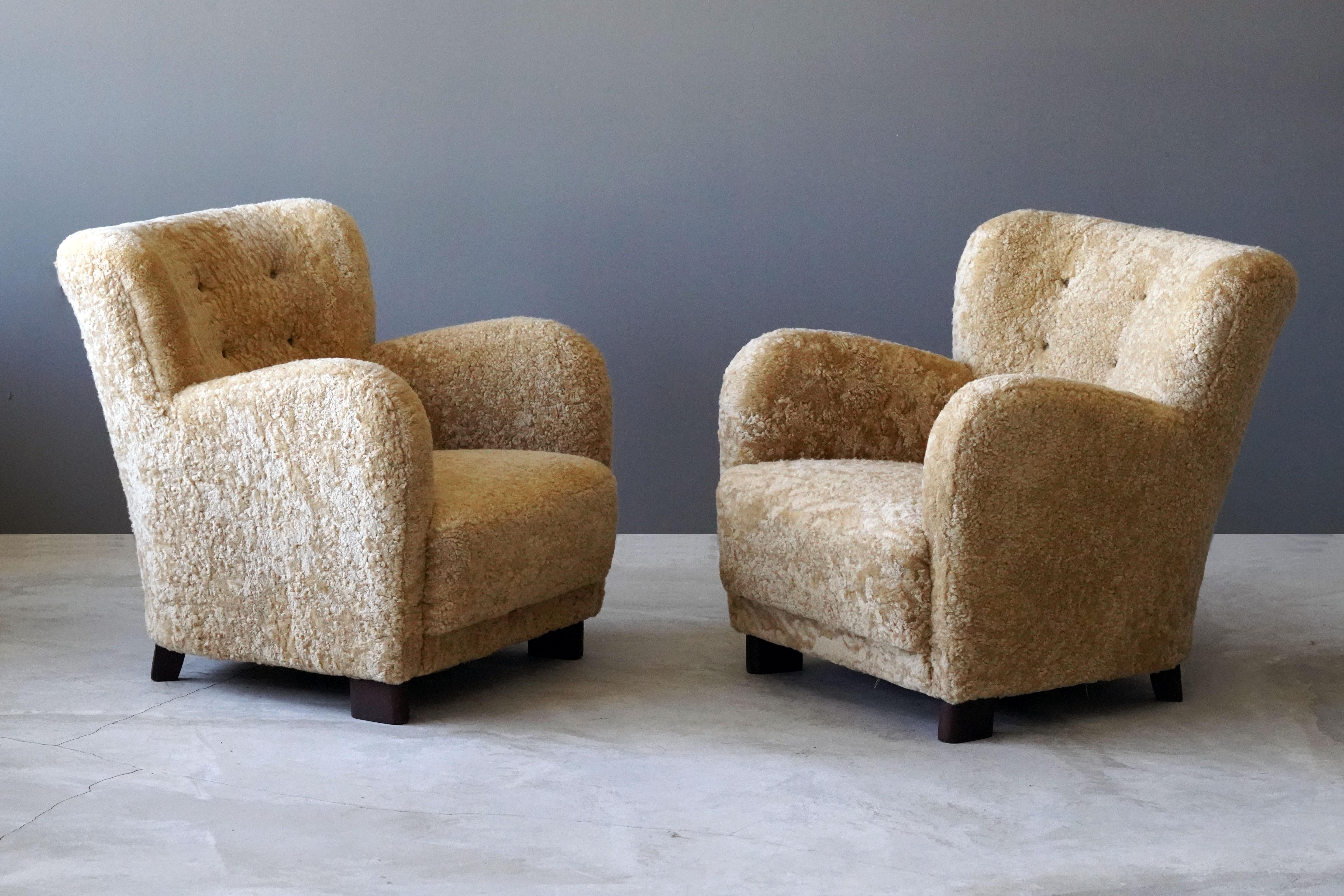 A pair of organic lounge chairs. Reupholstered in brand new sheepskin. Design and production attributed to Fritz Hansen (compare to model 1669 for similar design).

Other designers of the period include Flemming Lassen, Arnold Madsen, Philip