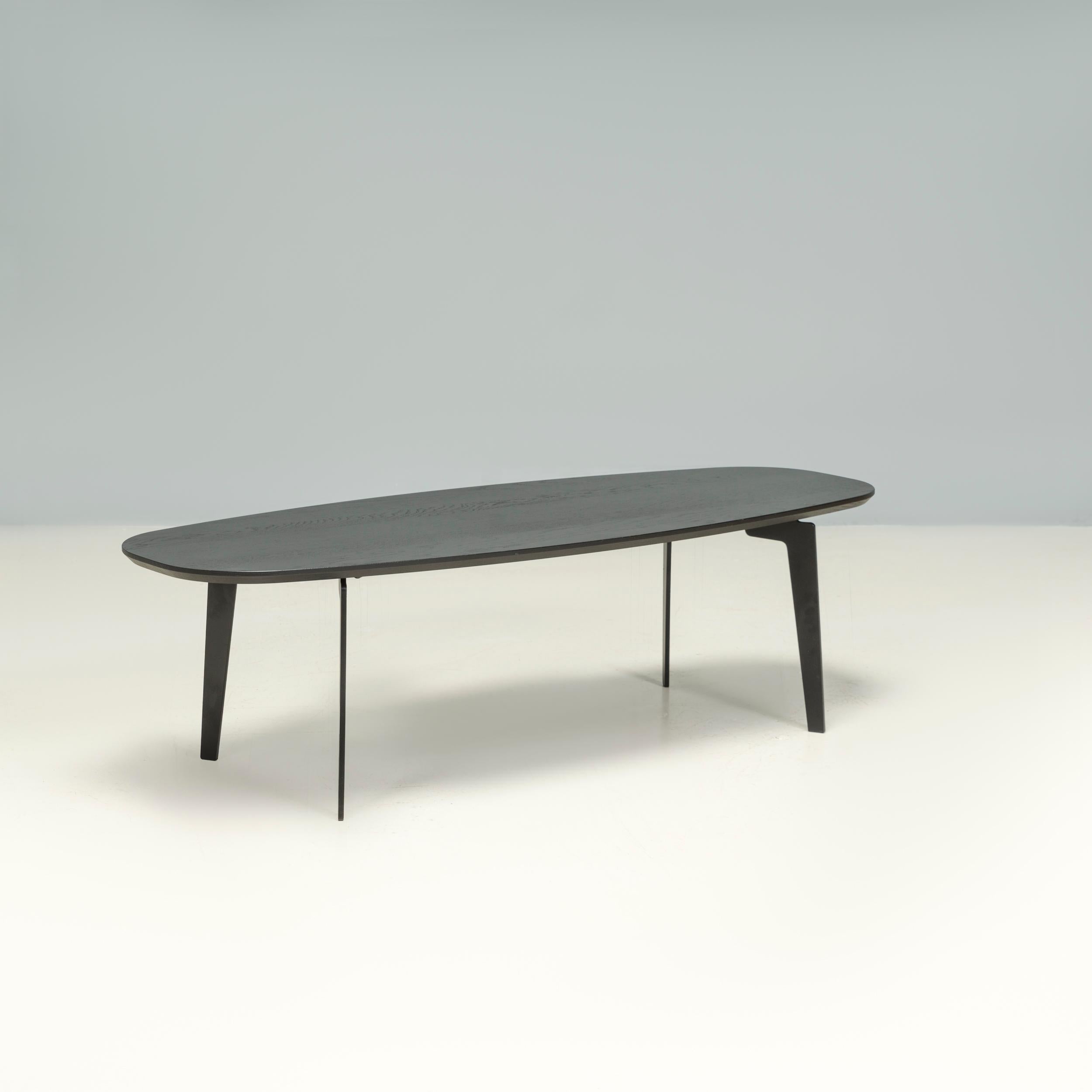Designed in Denmark by Fritz Hansen in 2014, this coffee table was manufactured in Sweden in 2017 and forms part of the JOIN™ collection.

With an oval shaped table top in black oak, the coffee table has an angular four-legged base, constructed from