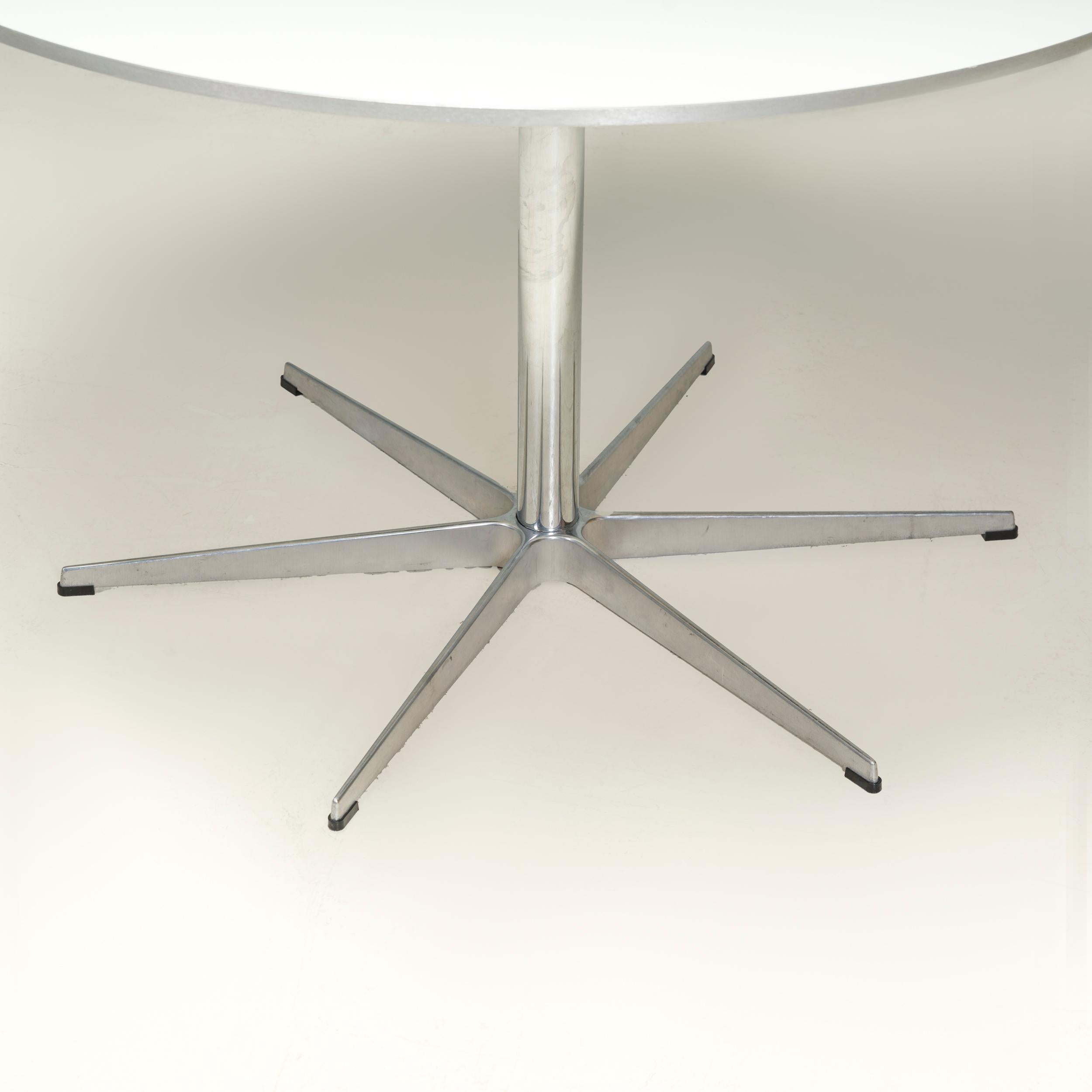 Originally designed by Arne Jacobsen for Fritz Hansen, the Circular table is a true design classic. 

The table features a 6-star base in a satin polished aluminium finish with a circular table top in white laminate chipboard with a matching