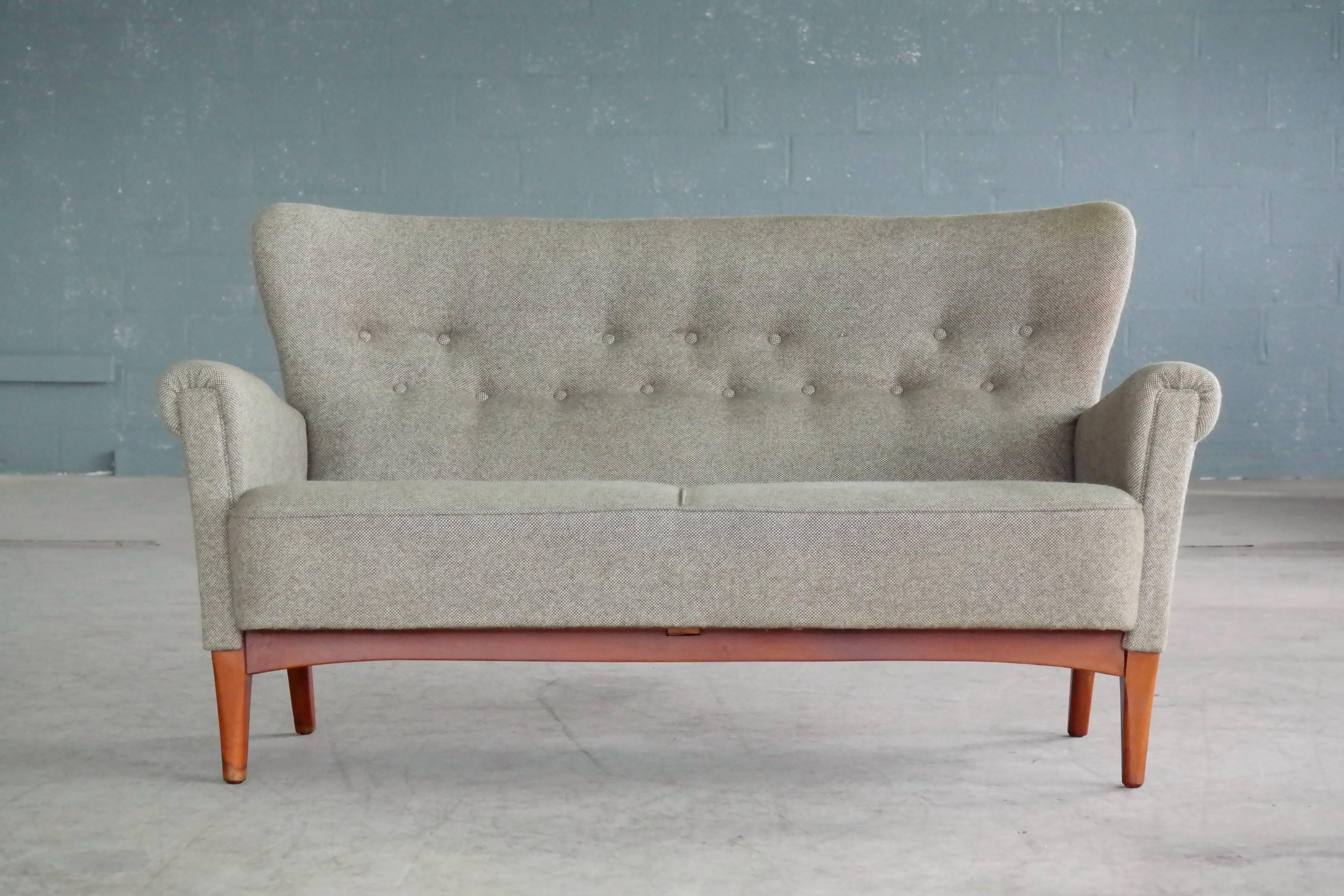 Very elegant settee or two-seat sofa made by Fritz Hansen sometime in the early to mid-1950s in Copenhagen, Denmark. The frame is construed similar to Fritz Hansen's armchairs of the 1940s allowing it to be disassembled without use of tools.