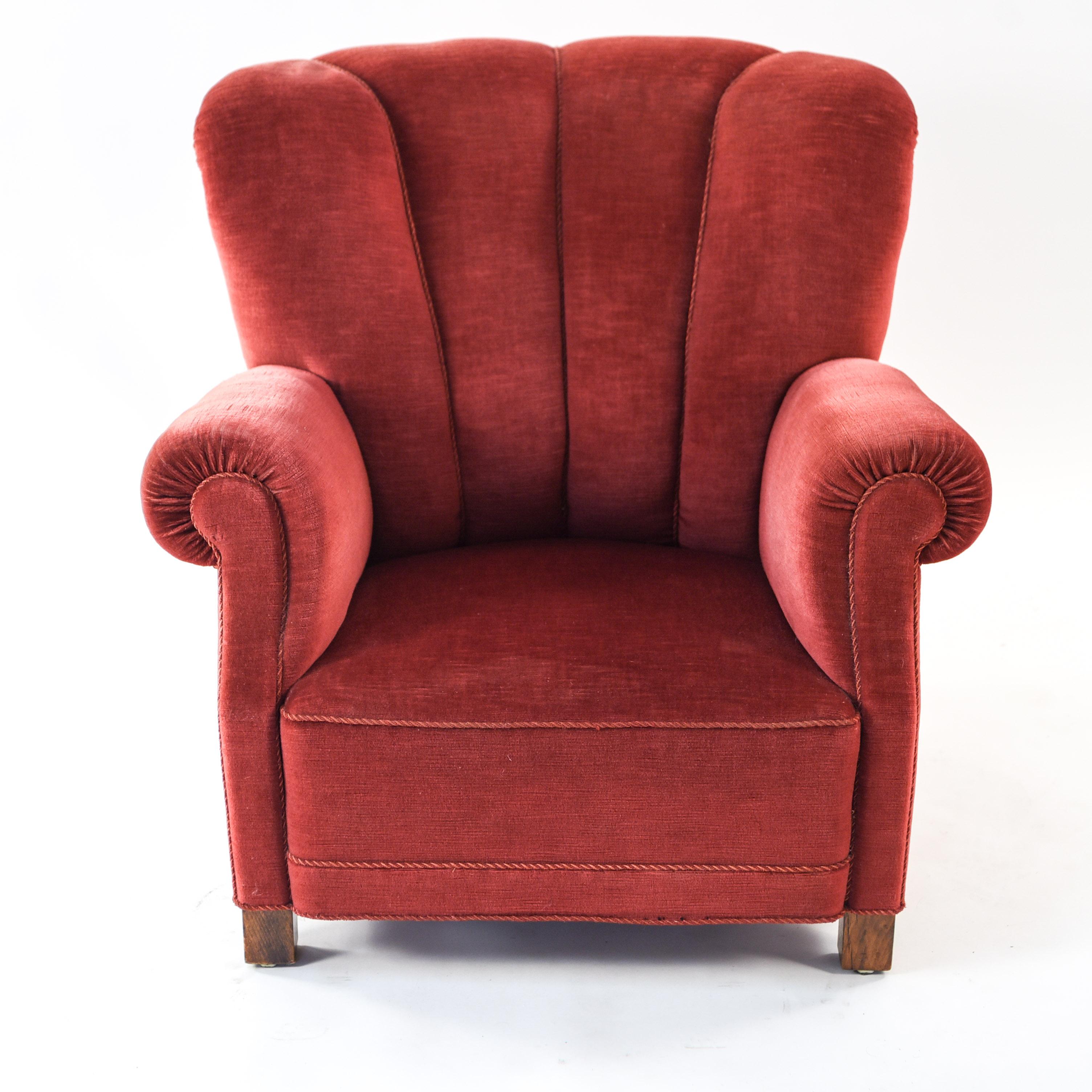 This fabulous wingback chair is fit for a king or queen. Made by Fritz Hansen, circa. 1940s, and believed to be model 1519. Featuring a scalloped back and scroll form arms, this extravagant lounge chair is upholstered mohair.