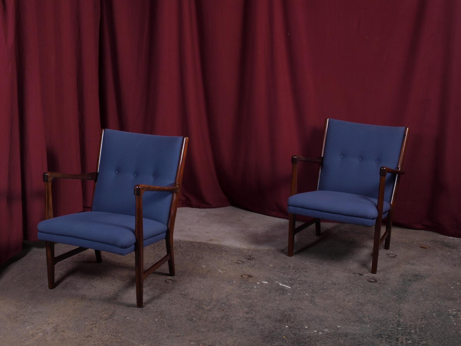 Indulge in the timeless elegance of mid-century design with these two blue armchairs from Fritz Hansen, complete with their original stamp of authenticity. Crafted in the 1950's / 1960s from beautifully dark-stained beech wood, the chairs feature