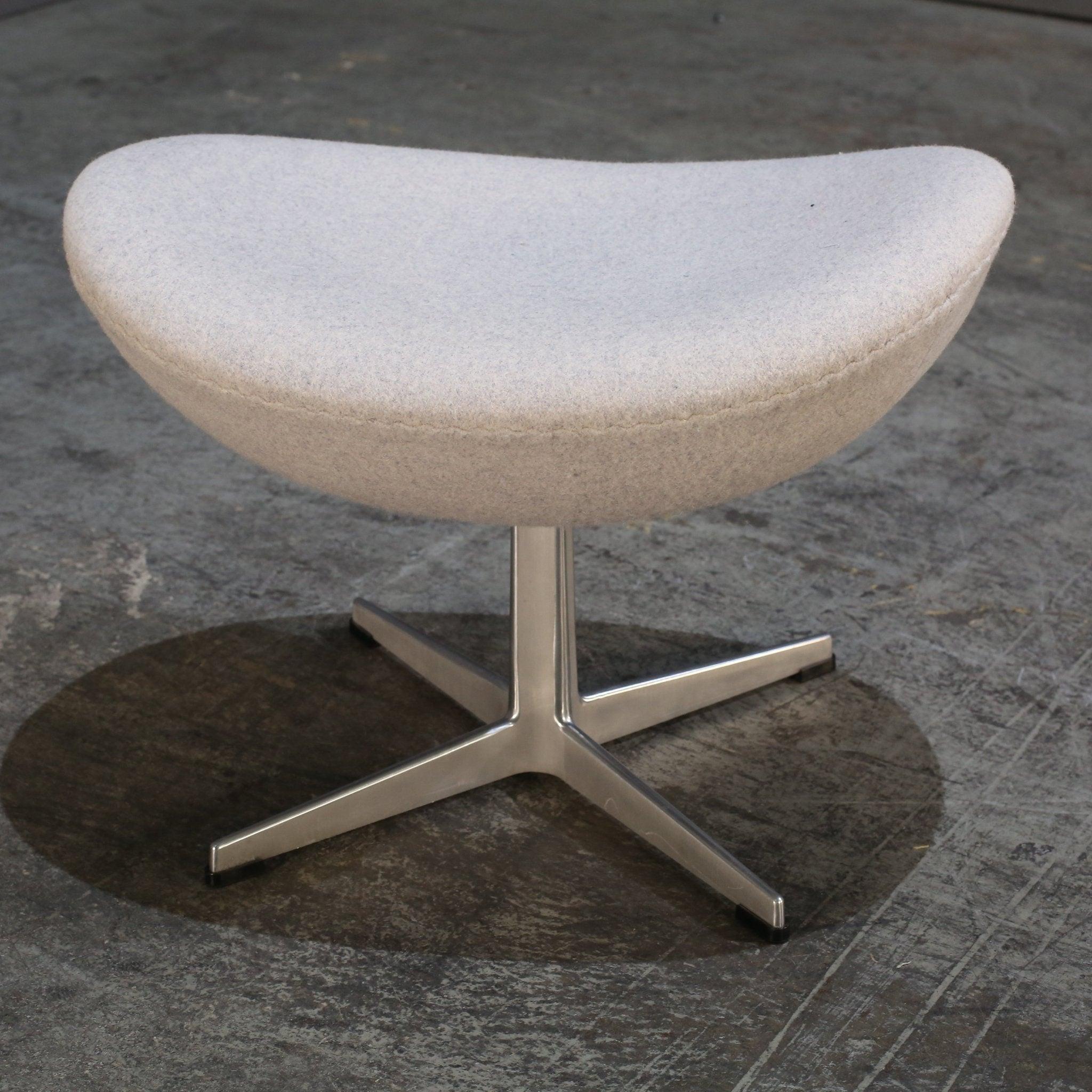 Introducing the iconic Egg Footstool by renowned designer Arne Jacobsen, exclusively from Fritz Hansen. This stunning piece is a true statement of luxury and sophistication, perfect for adding a touch of elegance to any living space. Crafted with