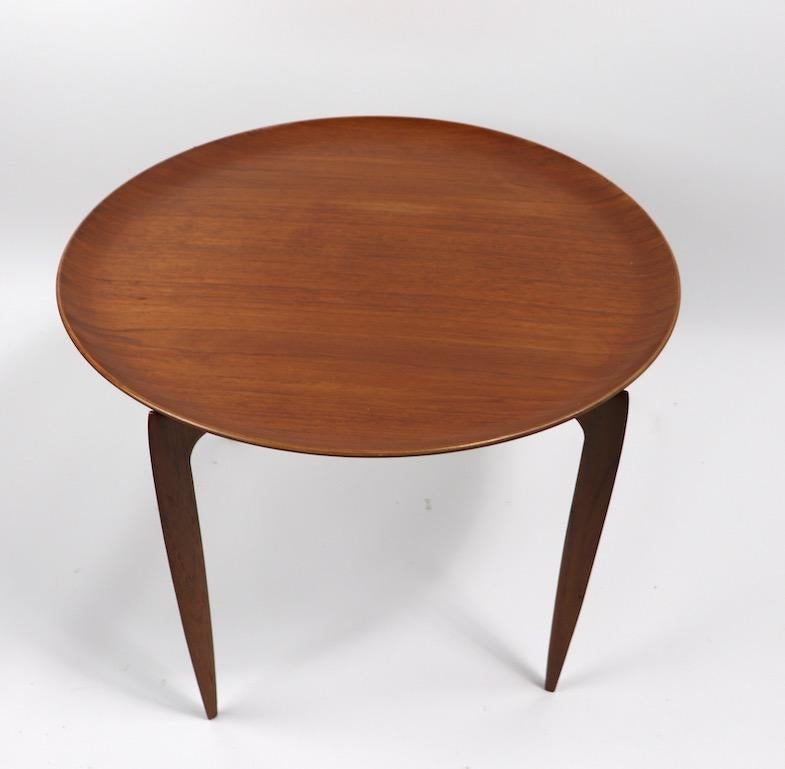Classic Danish folding base tray top occasional table in teak. This example is in very good, original condition, showing only light cosmetic wear, normal and consistent with age, marked on both base and top, as shown. Designed by Hans Engholm for