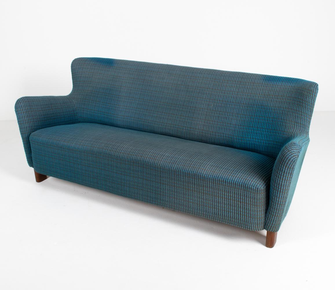 Inspired by Mogens Lassen, the timeless Model 1669 sofa by Fritz Hansen features bold curved arms and a subtly winged back. Finished in turquoise tweed fabric with classic splayed beechwood legs, this fabulous example can easily seat three to four