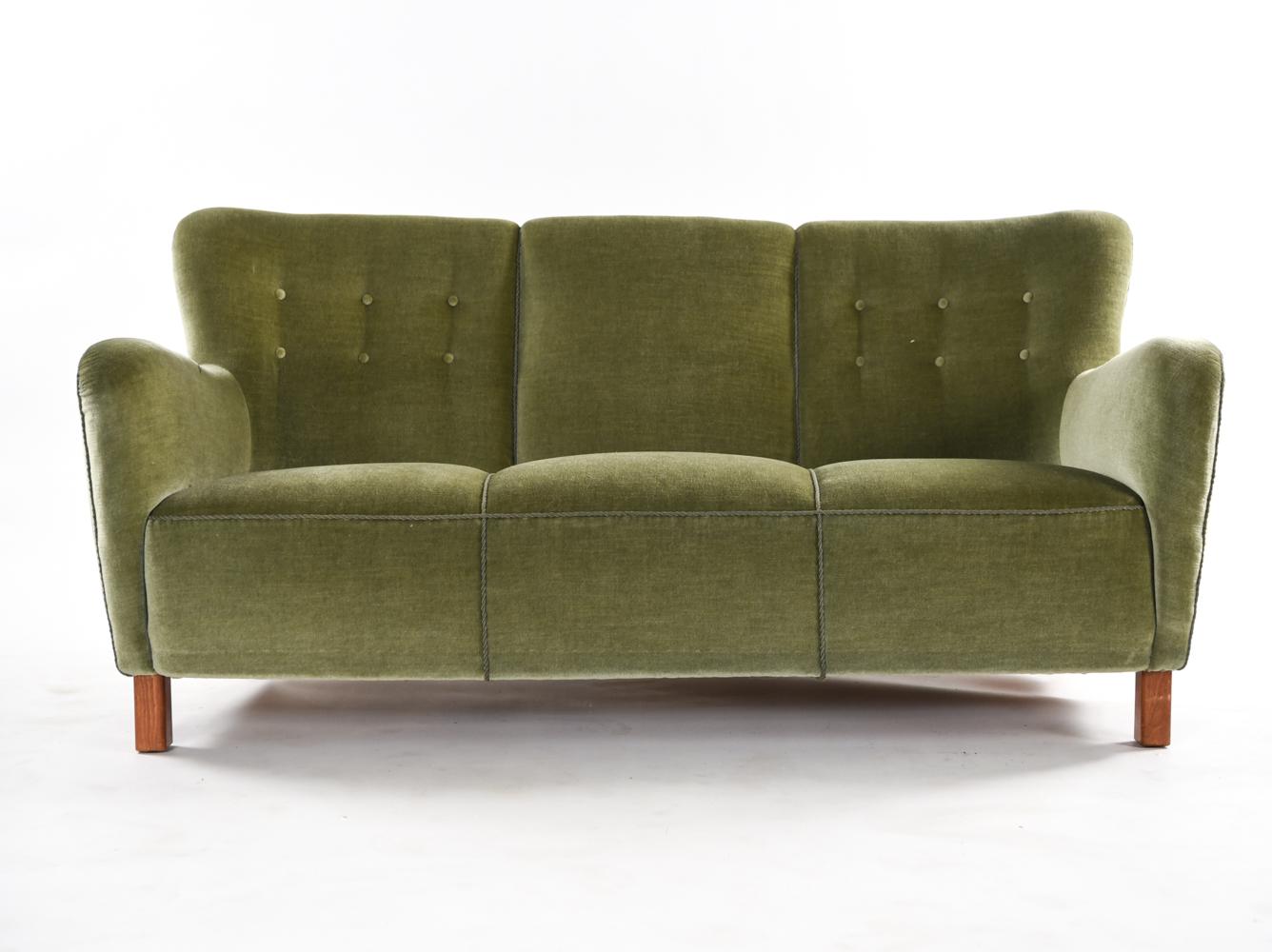 A model 1669 sofa by Fritz Hansen in the style of Mogens Lassen which can seat three comfortably. A timeless Art Deco inspired design with tufted upholstery.