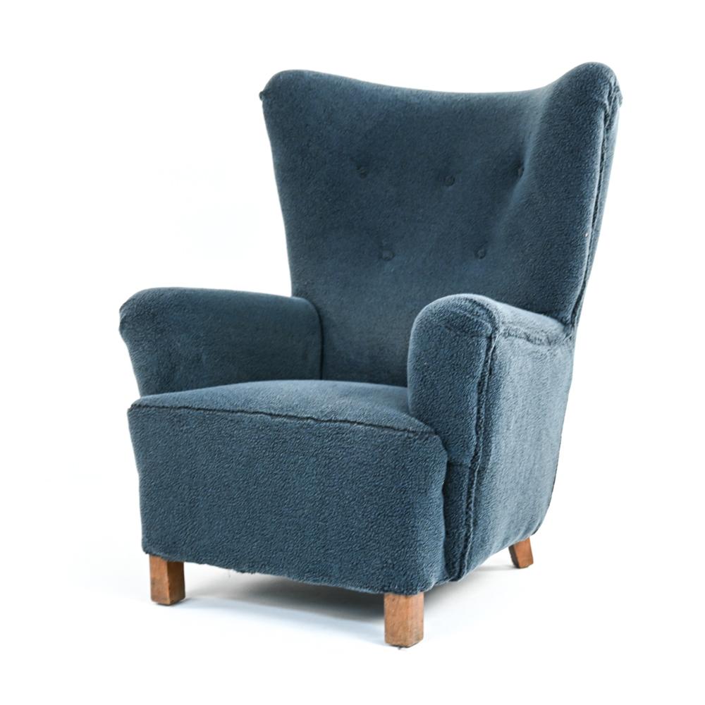 An impressive, rare Danish mid-century wingback lounge chair by Fritz Hansen, model 1672. With a striking wingback form and angular armrests, this c. 1946 chair is an iconic example of early Scandinavian modern design. In button tufted dyed navy