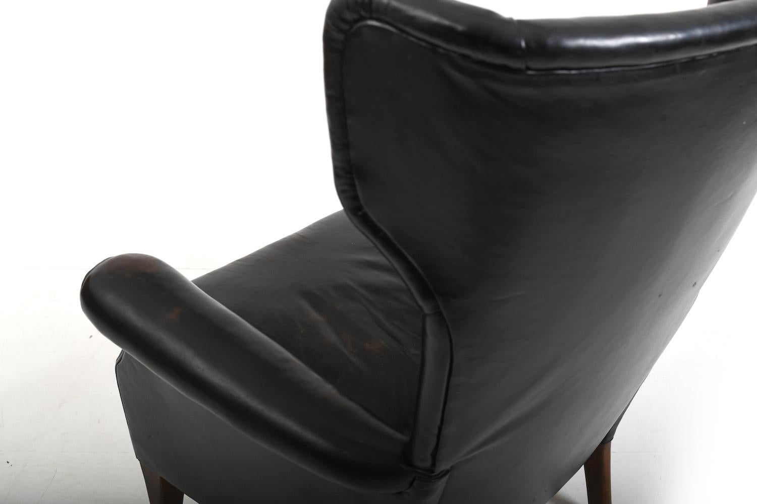 20th Century Fritz Hansen, model 8023 wingback lounge chair. Original patinated black leather For Sale