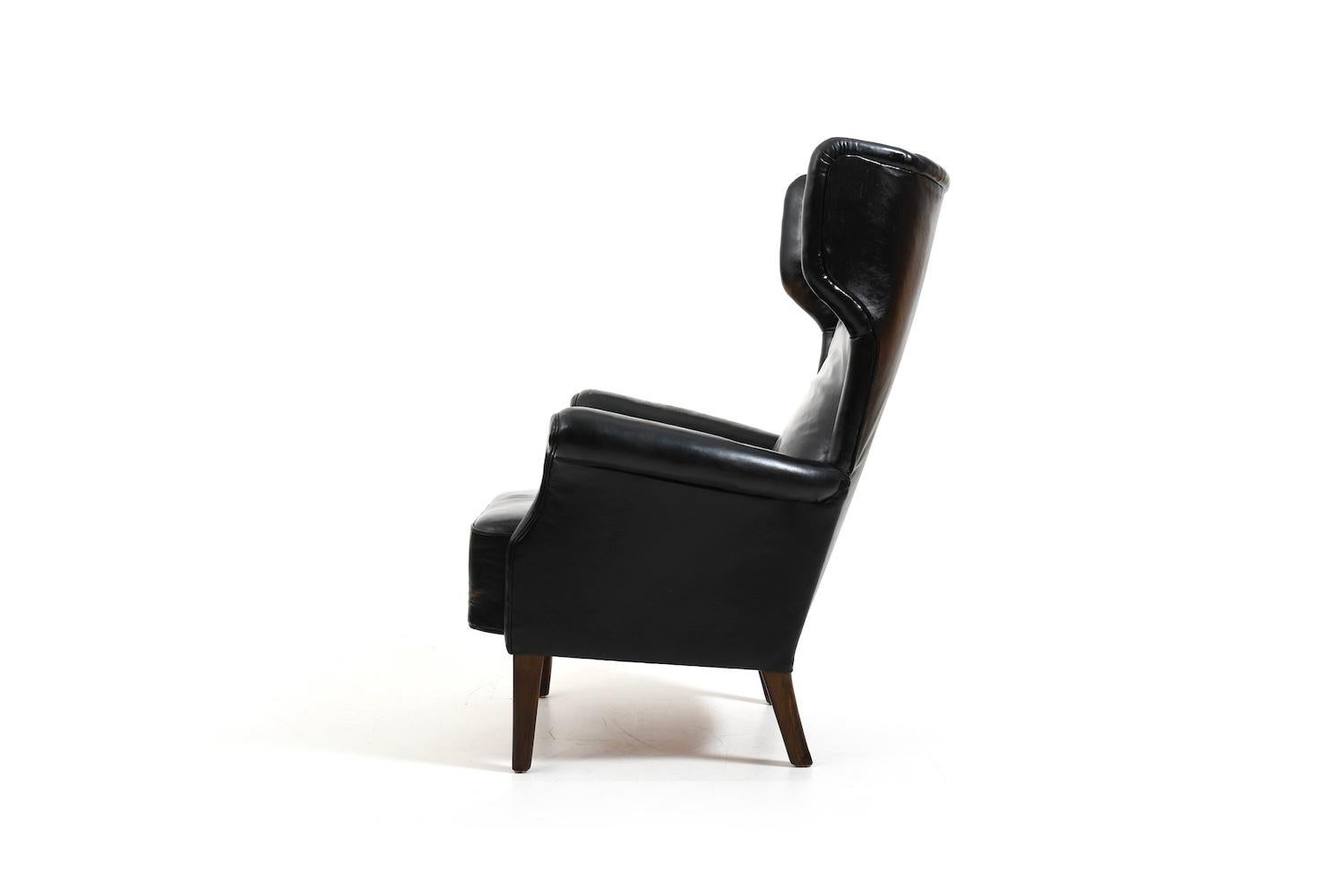 Leather Fritz Hansen, model 8023 wingback lounge chair. Original patinated black leather For Sale