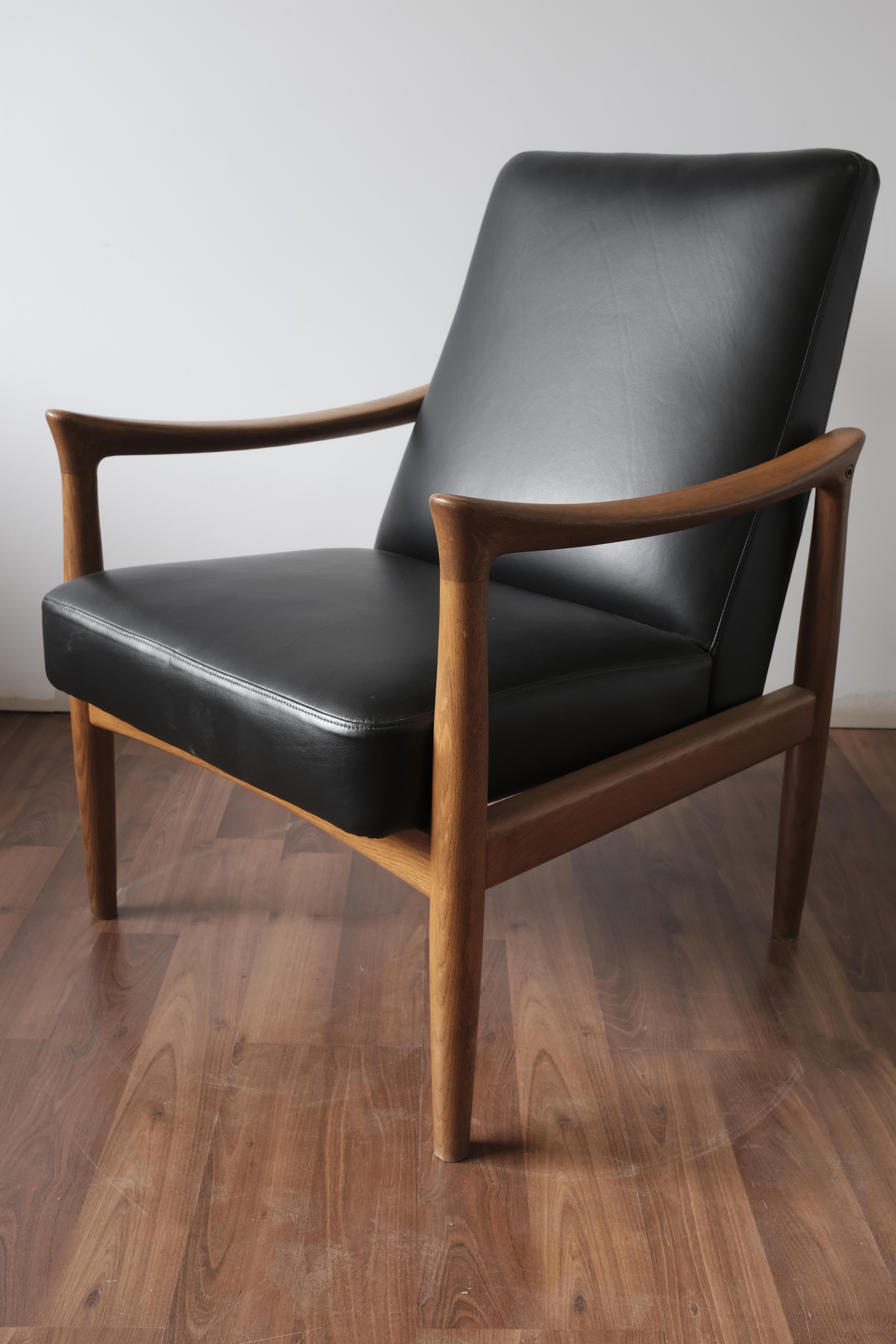 Armchair made in Denmark by Fritz Hansen.

The oak frame has been recently refinished while the seat and back have been reupholstered in black leather.