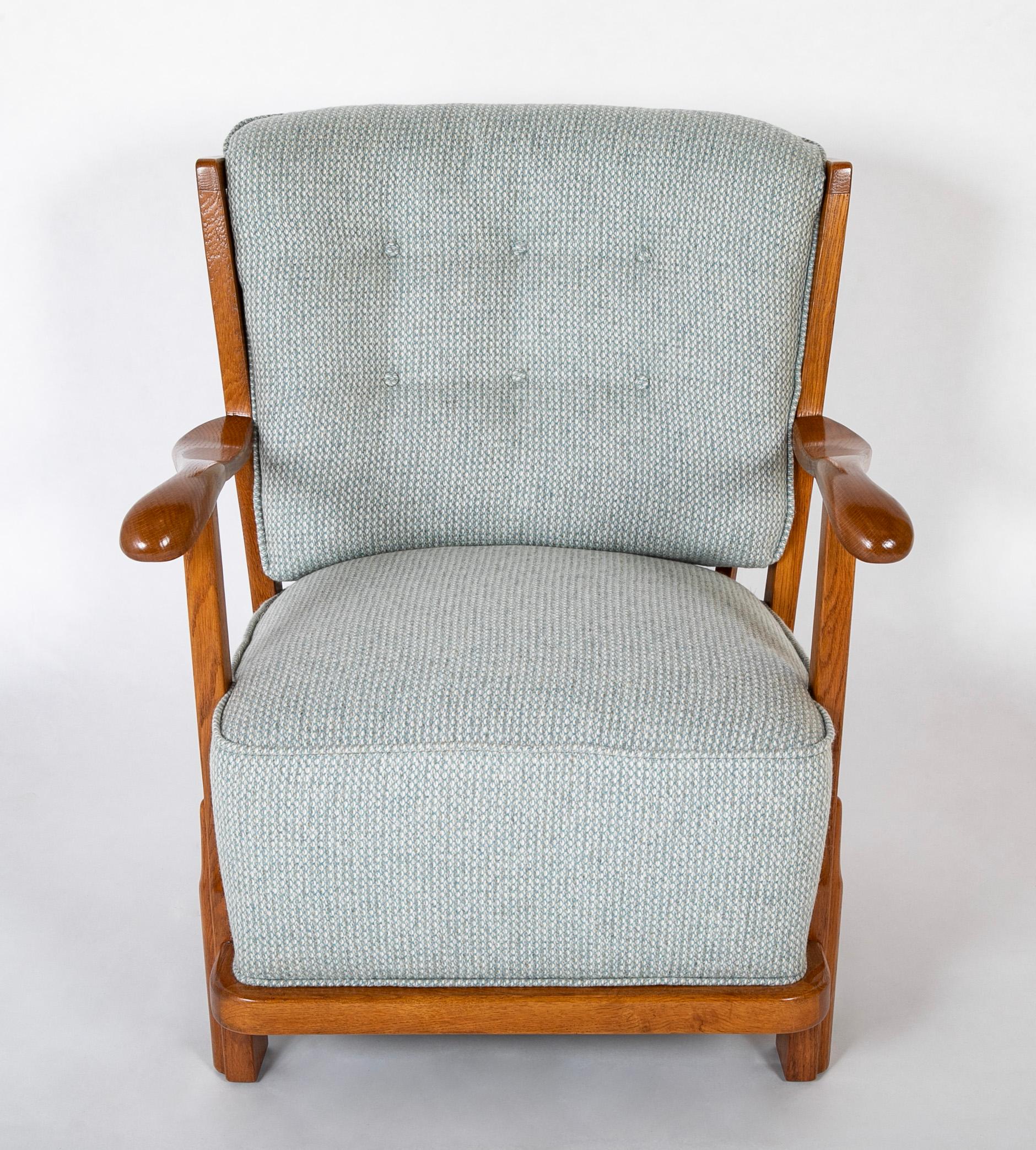 A Fritz Hansen armchair with deep upholstered seat and button fitted upholstered back having an oak frame.
