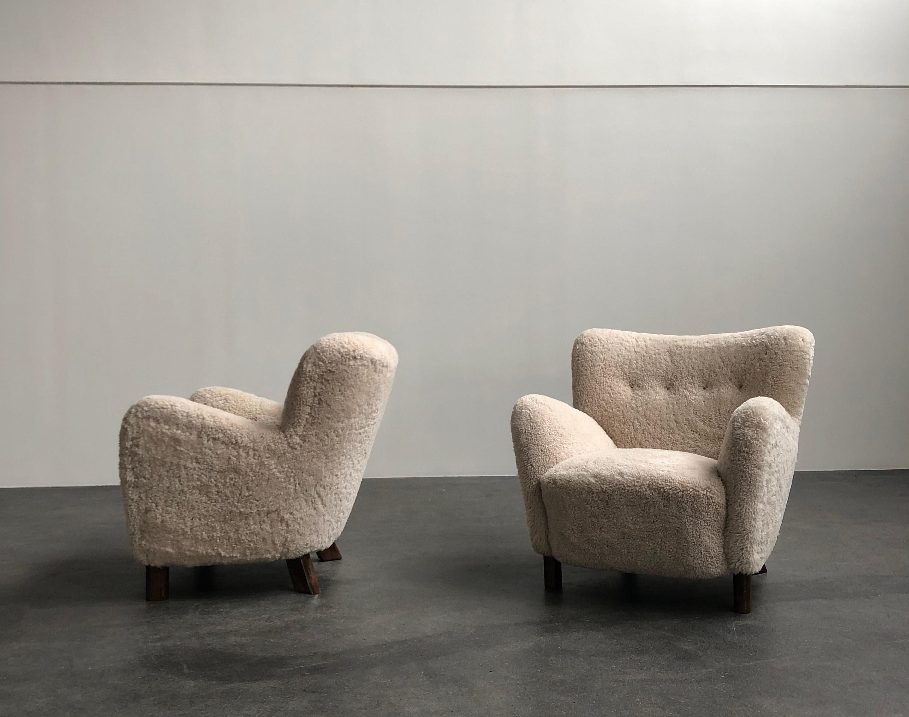 Pair of Fritz Hansen easy chairs, model 1669, circa 1930s.

Sculptural chair re-upholstered in beige sheepskin, legs of stained beech. All work carried out as original with filling in organic materials and bottom finish with nails.

Price is for the