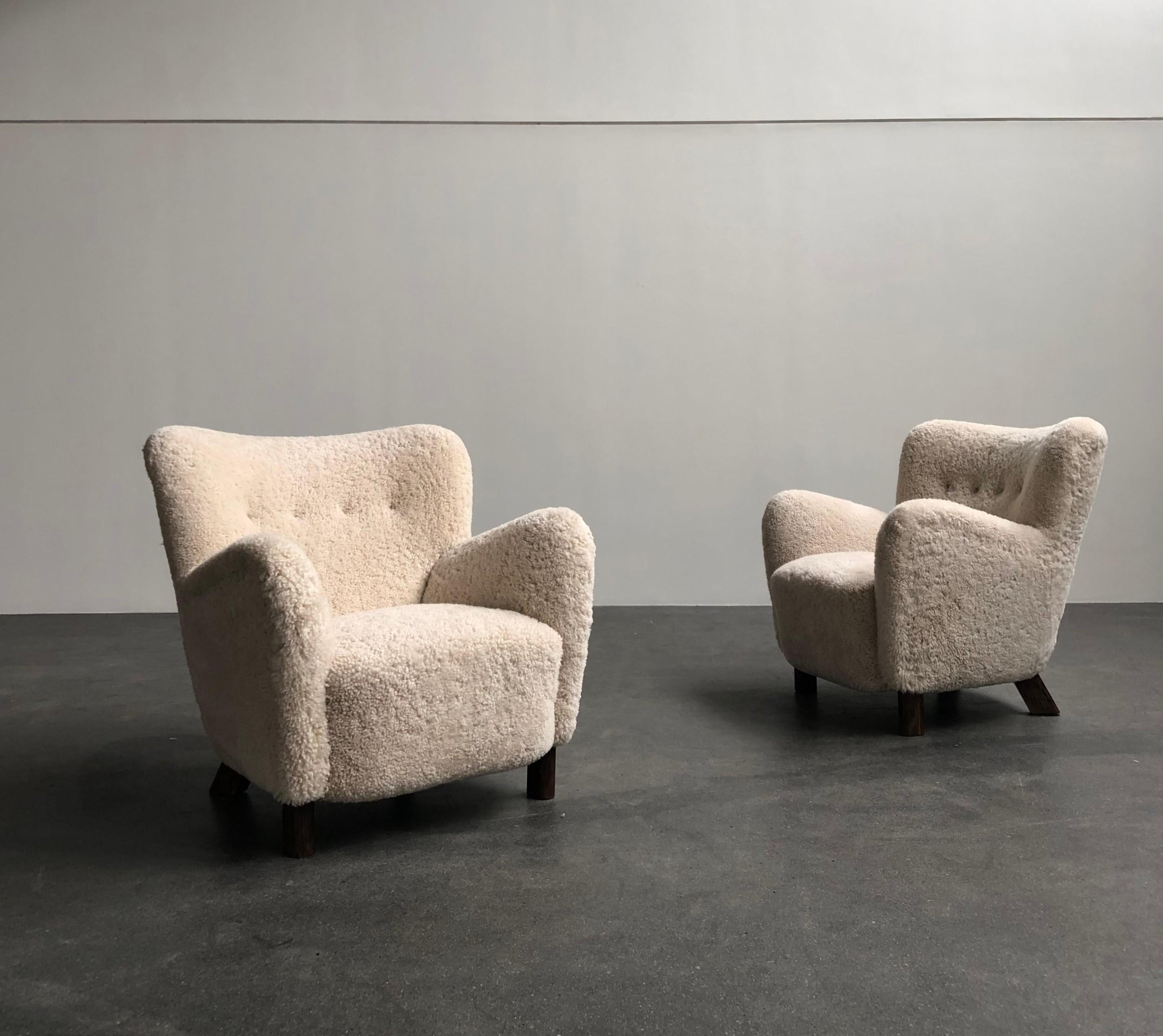 Pair of Fritz Hansen easy chairs in sheepskin, model 1669, 1930s

Sculptural chairs re-upholstered in sheepskin, legs of stained beech. All reupholstery work carried out with filling in organic materials and bottom finish with nails.
