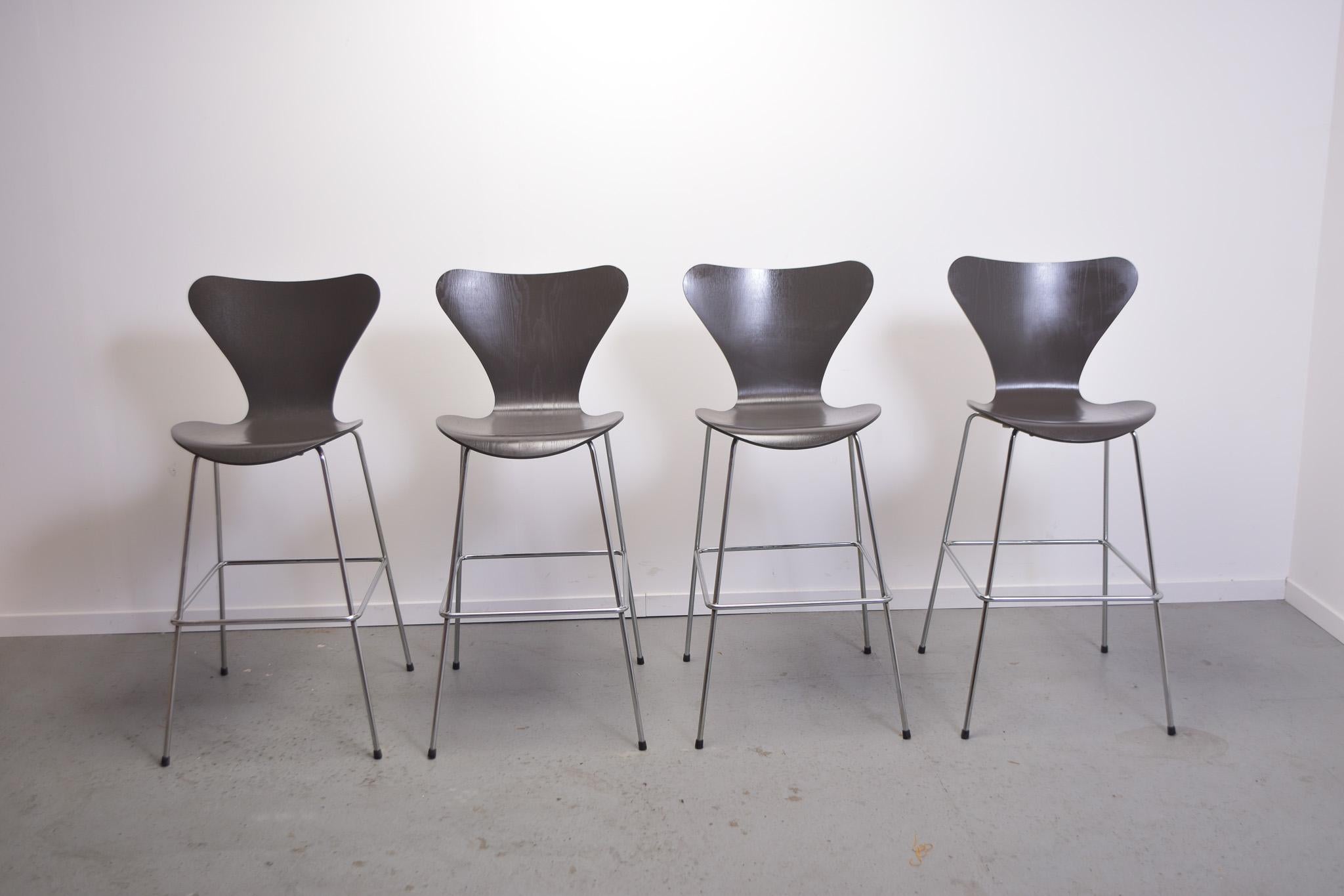 Set of 4 Frits Hansen Series 7 Butterfly bar stools designed by Arne Jacobsen.

Shells in Dark grey oak with chrome base.